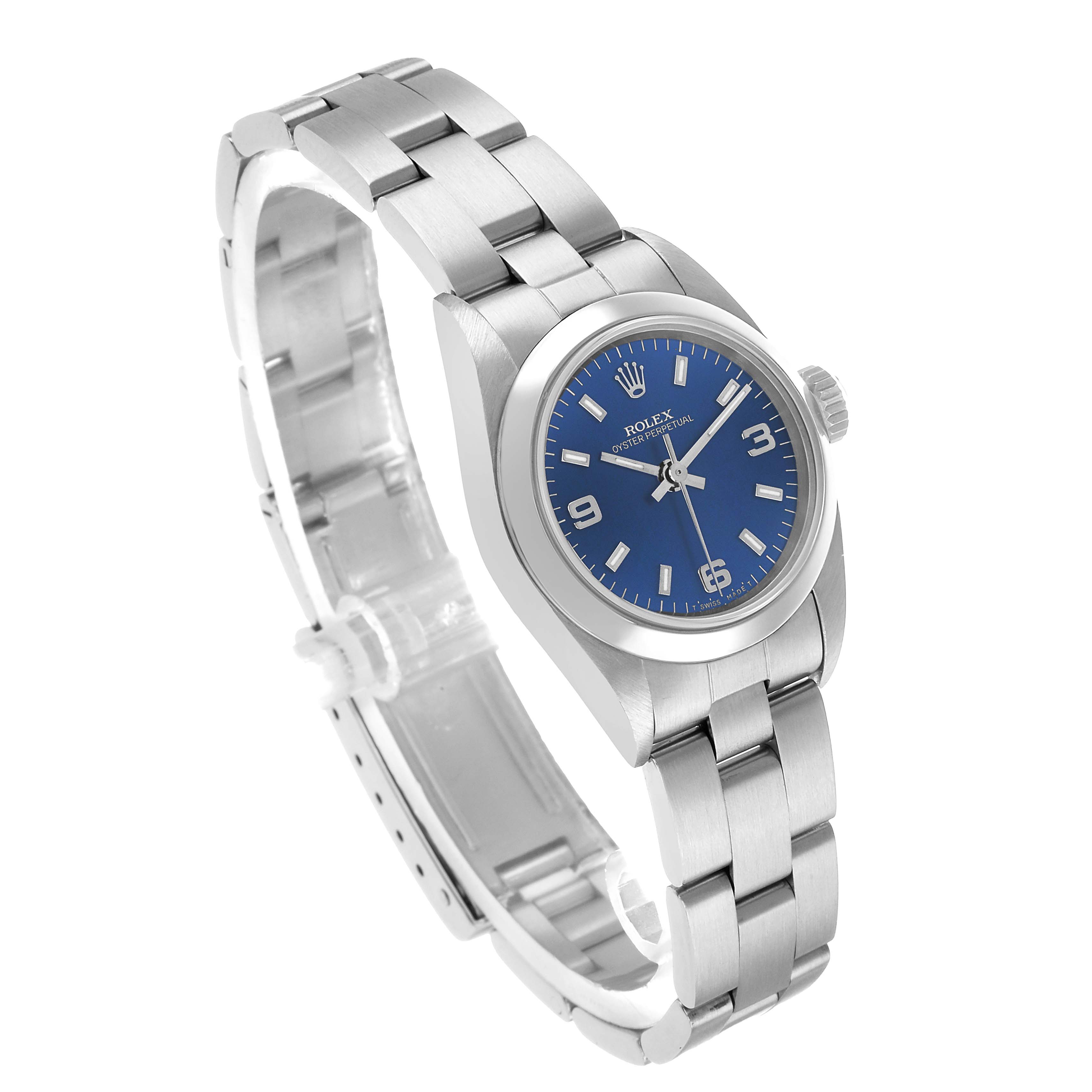 The Rolex Oyster Perpetual 67180 Women's Stainless Steel Blue Dial watch is shown at a tilted angle, displaying the face, bracelet, and crown.