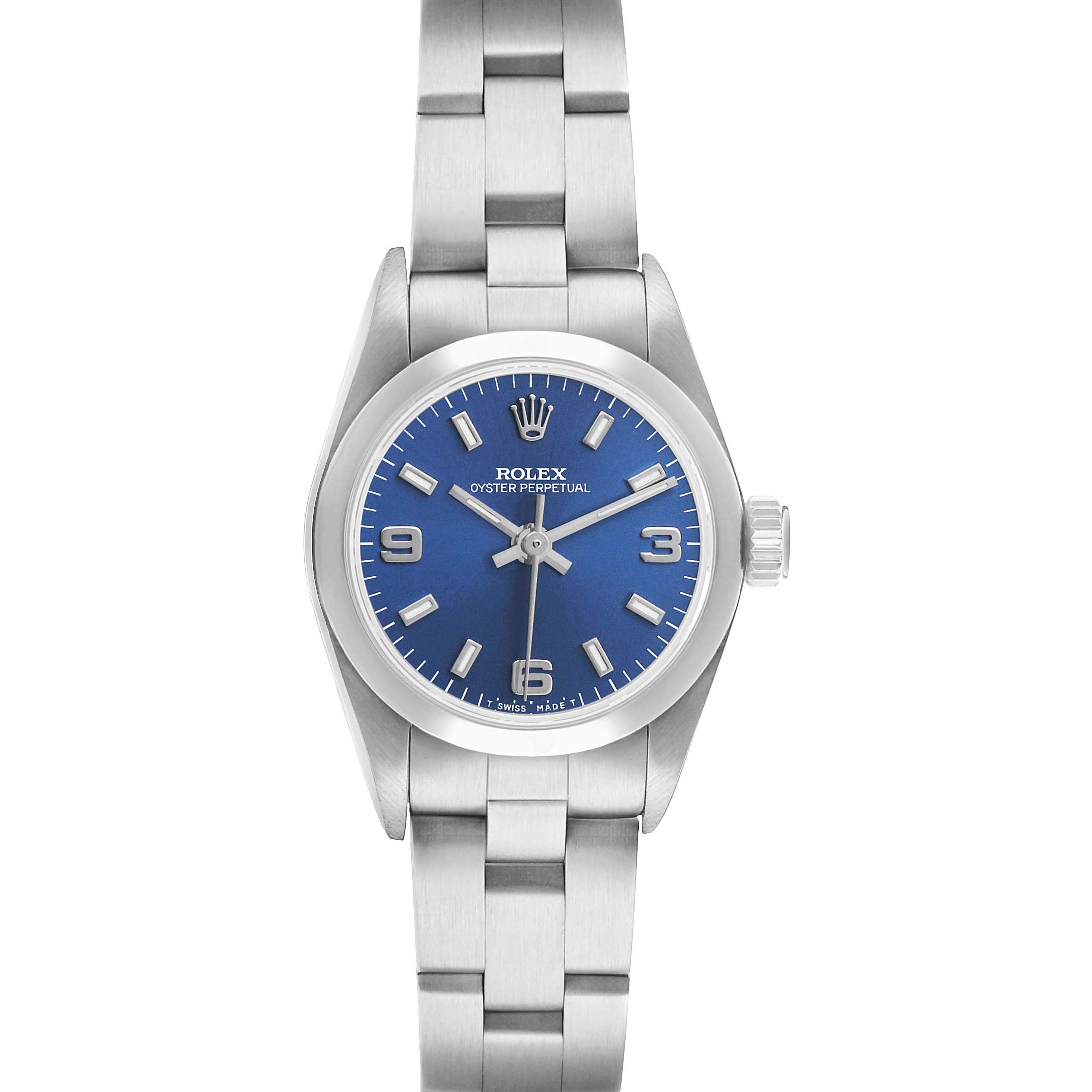 The Rolex Oyster Perpetual 67180 Women's Stainless Steel Blue Dial watch is shown from a top-down angle, highlighting its blue dial, bezel, and bracelet.