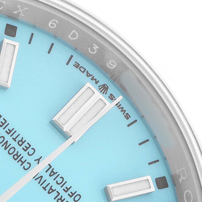 The image shows a close-up of the Rolex Oyster Perpetual 126000 Men's Stainless Steel Blue Dial's dial, highlighting the hour markers, hands, and part of the chapter ring.