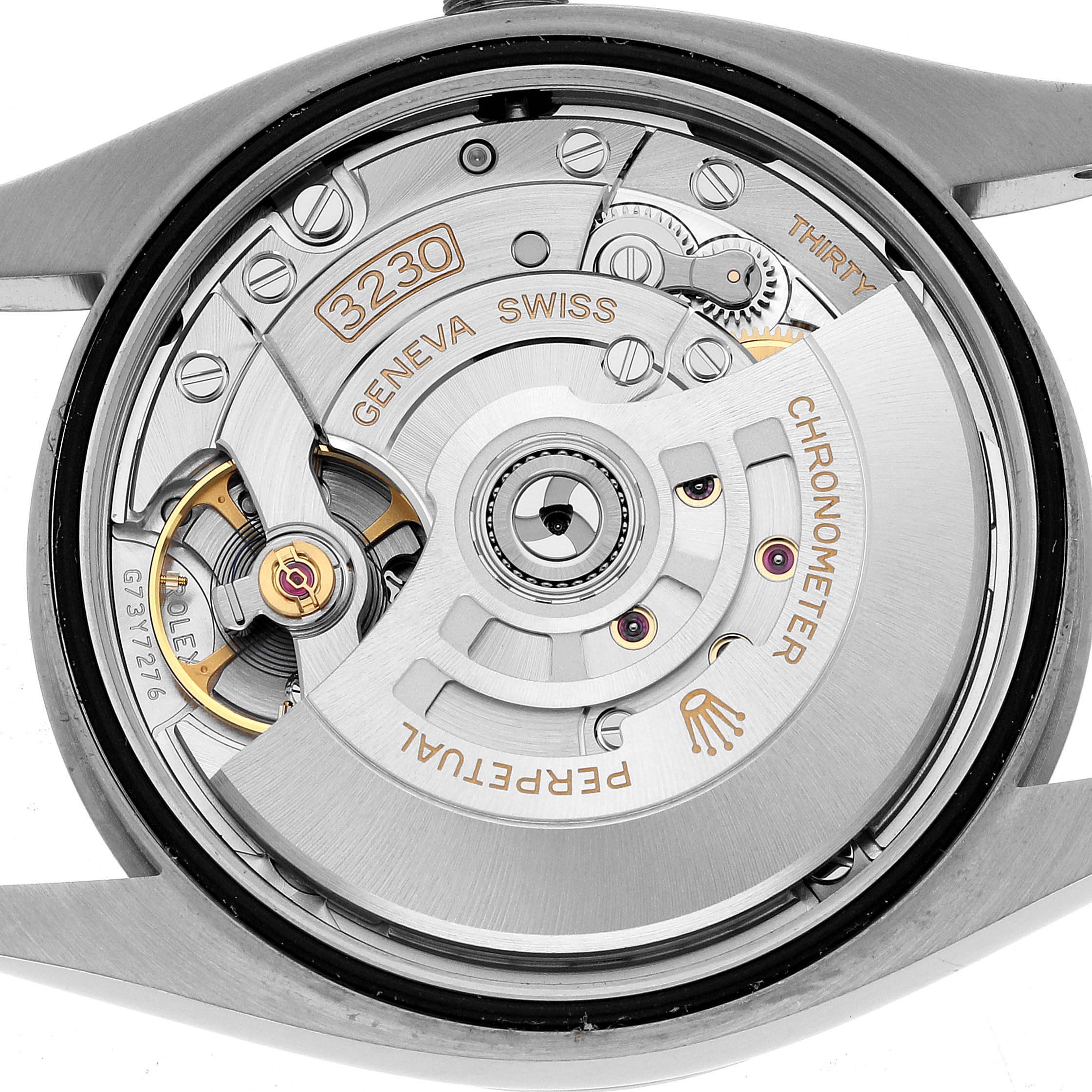 The image shows the back view of the Rolex Oyster Perpetual 126000 Men's Stainless Steel Blue Dial, displaying its mechanical movement and rotor.