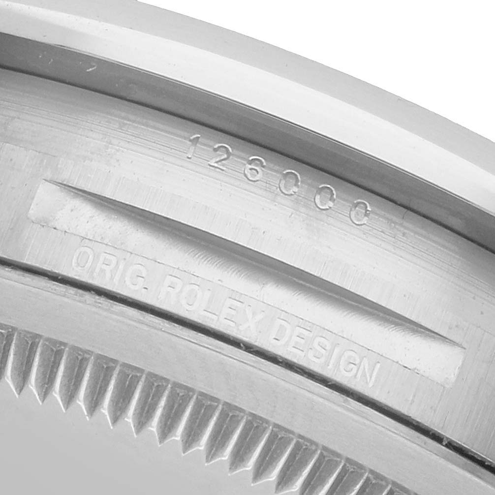 The image shows the side engraving and bezel of a Rolex Oyster Perpetual 126000 Men's Stainless Steel Blue Dial, highlighting its model number and "Orig. Rolex Design."