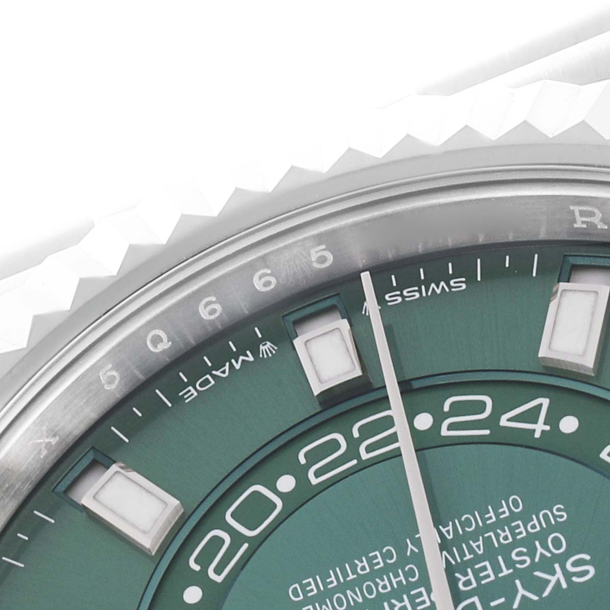 The image shows a close-up of the Rolex Sky-Dweller 336934 Men's Stainless Steel Green Dial 336934 Men's Stainless Steel Green Dial watch dial and part of the bezel, focusing on indices and time indicators.
