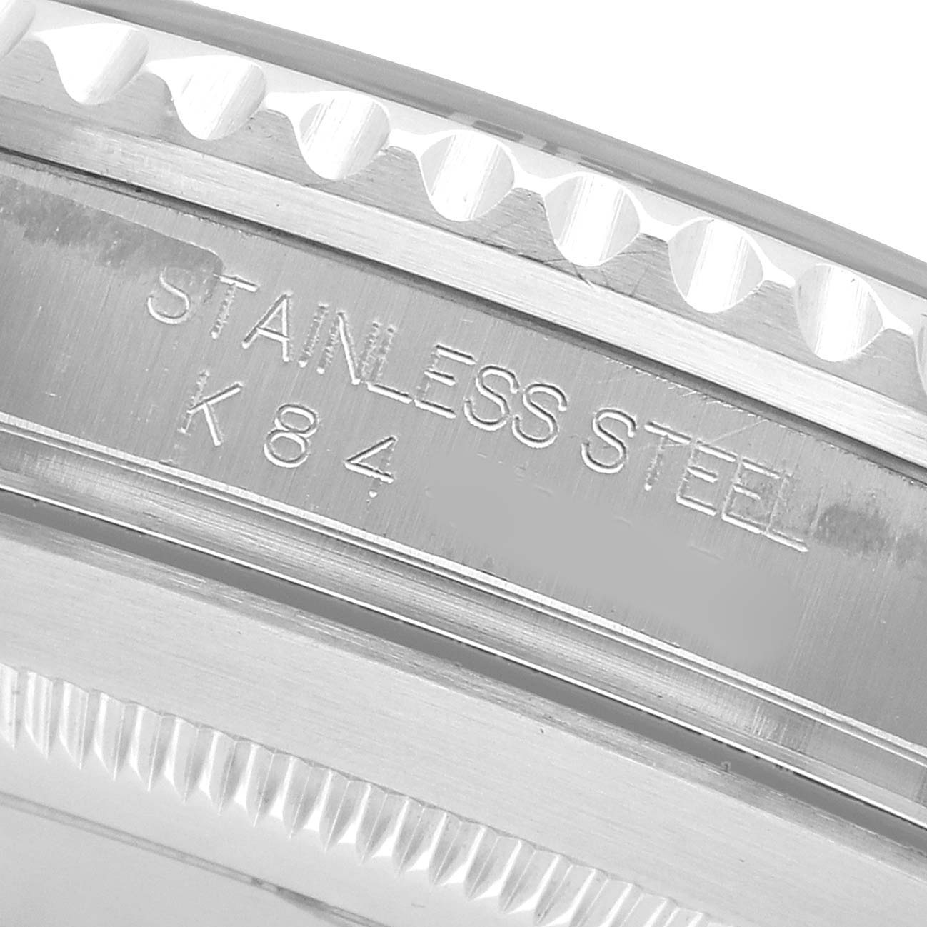 The image shows an angled close-up of the Rolex Submariner 16610 Men's Stainless Steel Black Dial's stainless steel case with engraved details.