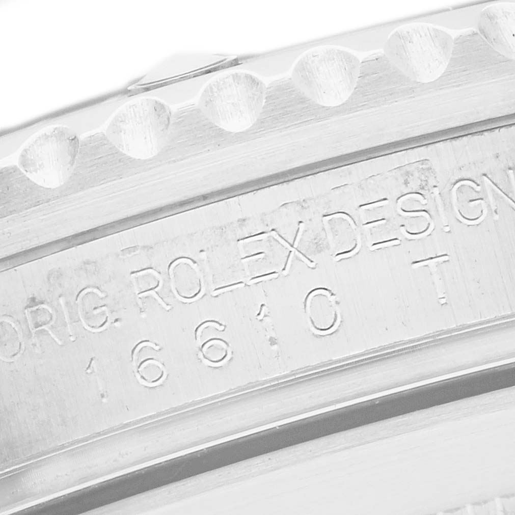 The image shows a close-up of the Rolex Submariner 16610 Men's Stainless Steel Black Dial's engraved case side with model number and design details.