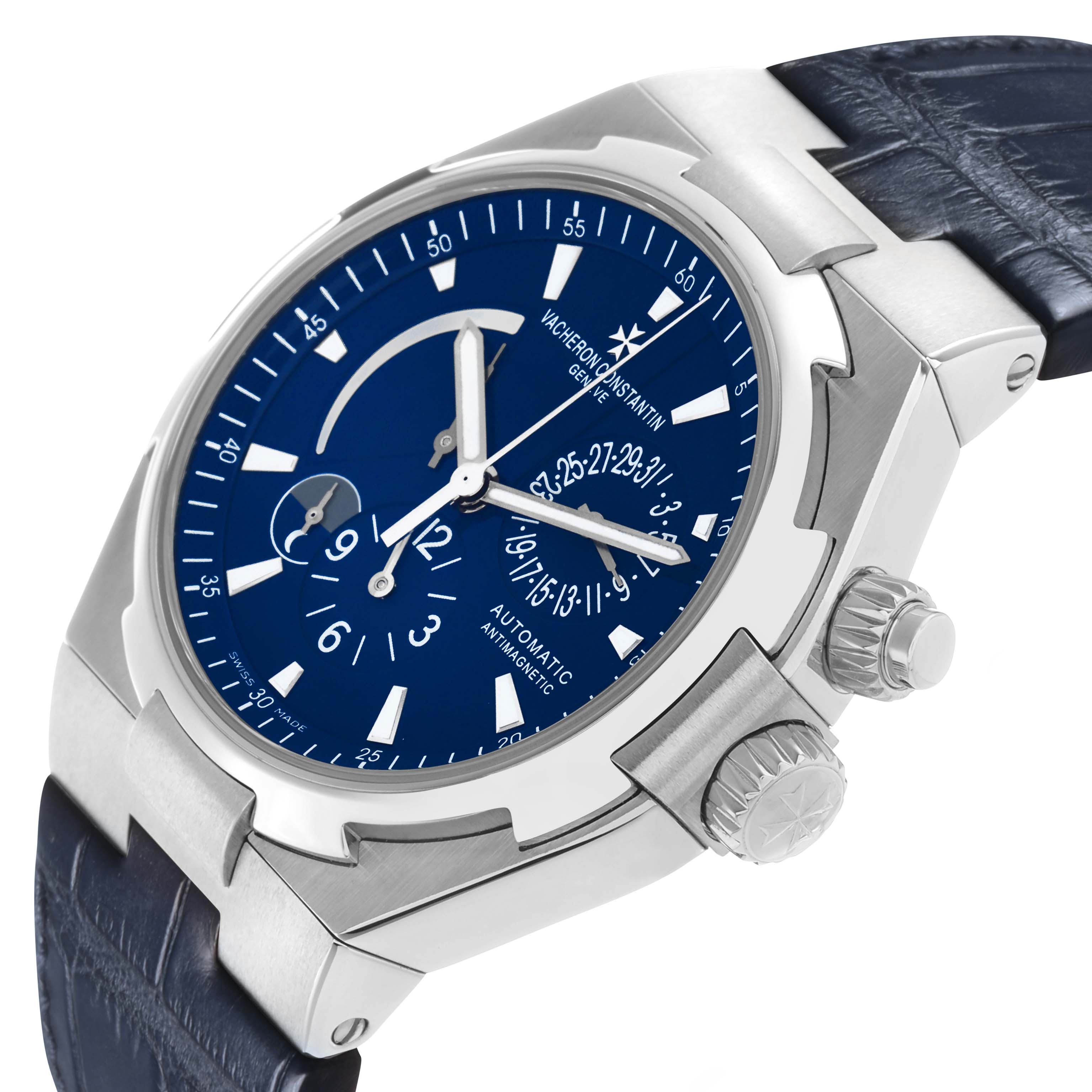 The Vacheron Constantin Overseas 47450 Men's Stainless Steel Blue Dial watch is shown at a three-quarter angle, highlighting the dial, crown, and strap.