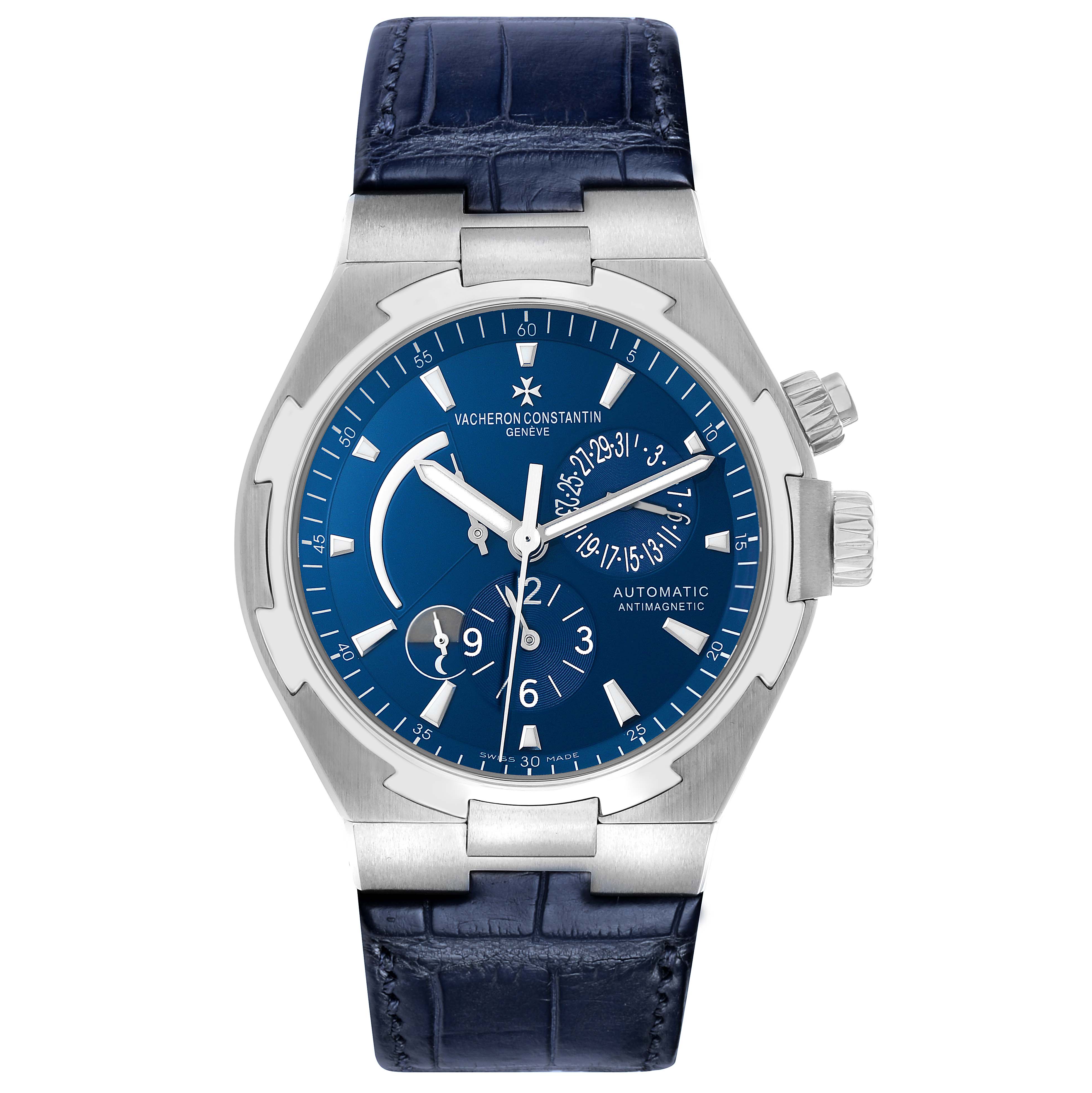 The Vacheron Constantin Overseas 47450 Men's Stainless Steel Blue Dial watch is shown from a front angle, displaying the blue dial, dual crowns, and leather strap.