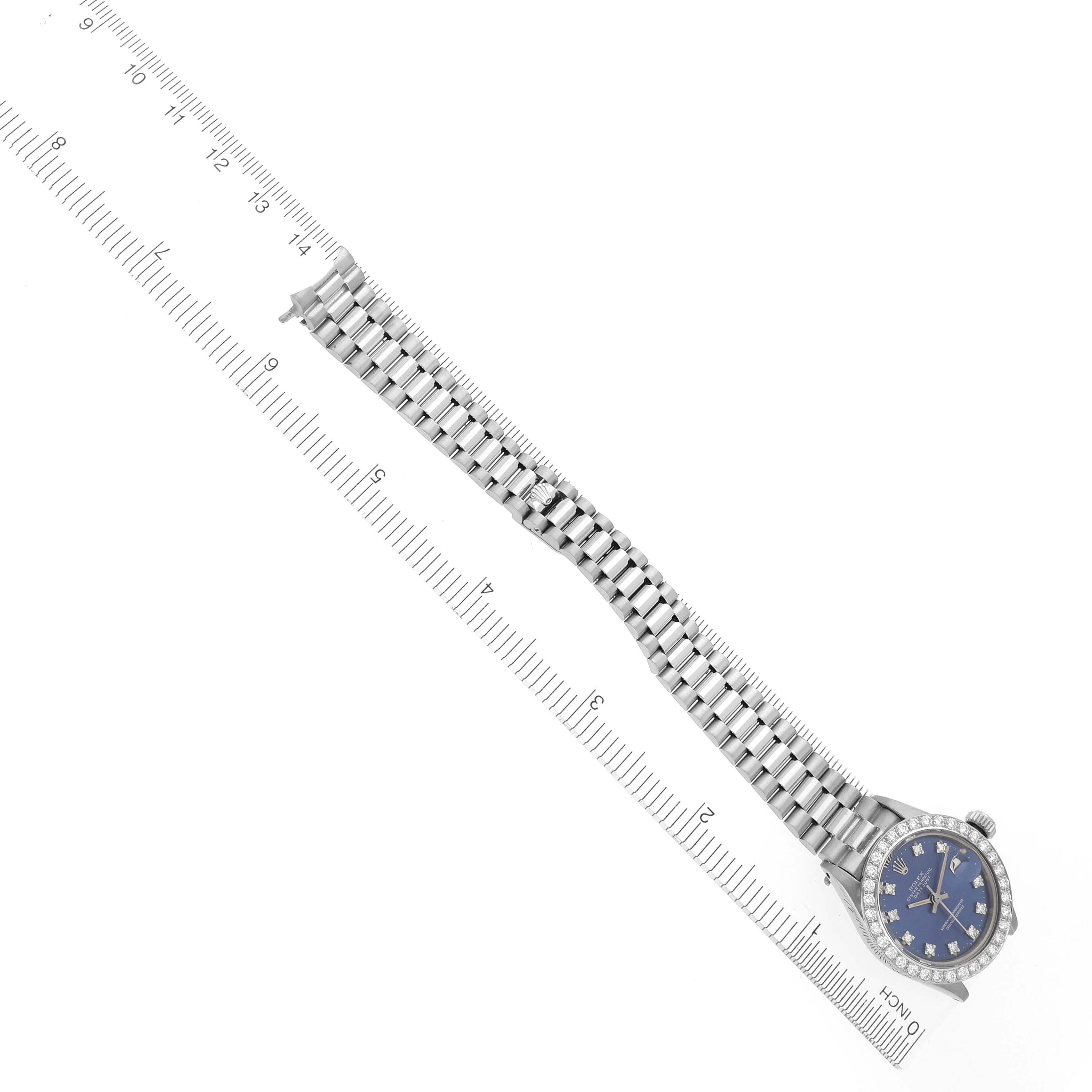 The image shows a Rolex President 6913 Women's White Gold Blue Dial 6913 Women's White Gold Blue Dial model watch at a slight angle, displaying the face, bracelet, and partial bezel on a ruler background.