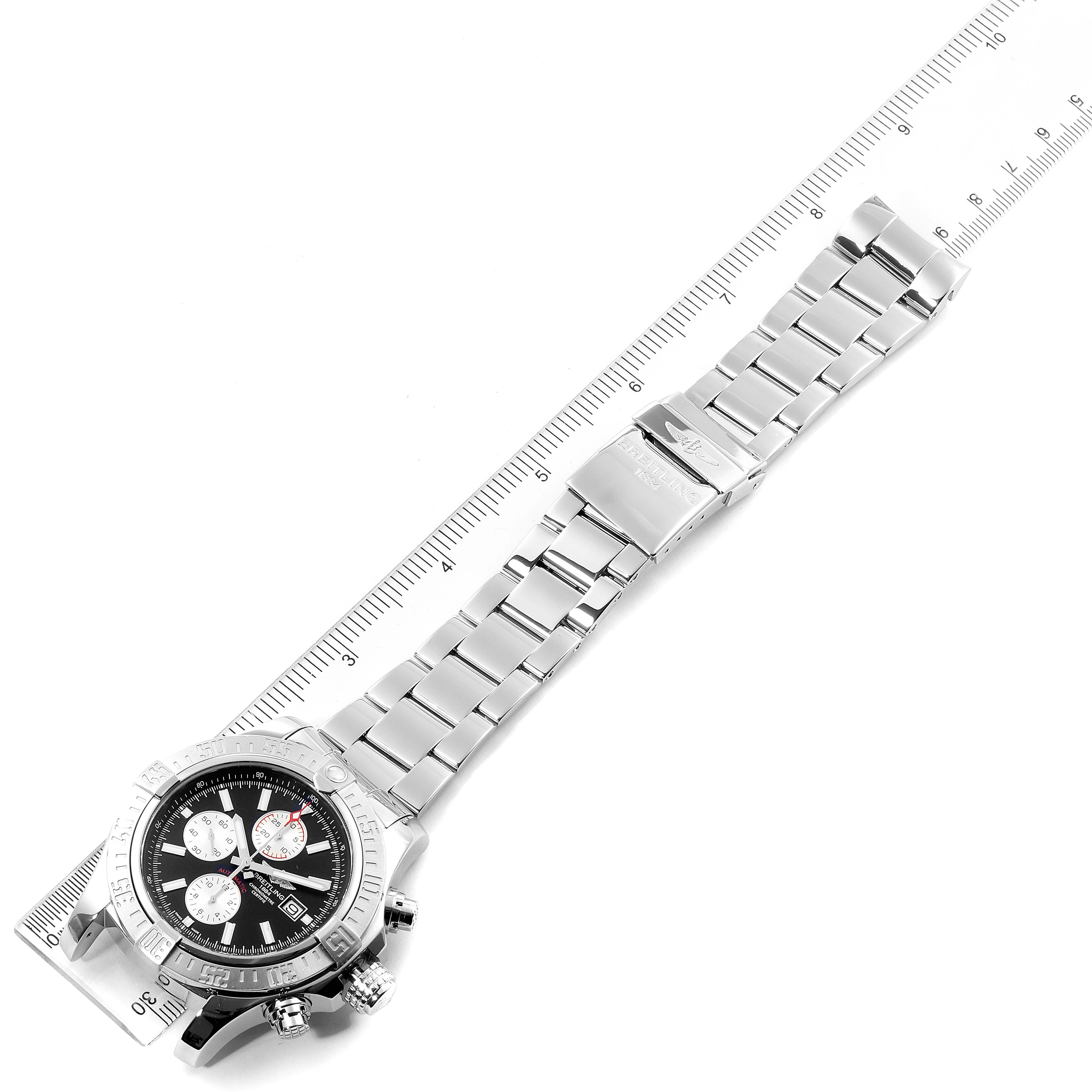 The image shows a top view of the Breitling Avenger A13371 Men's Stainless Steel Black Dial A13371 Men's Stainless Steel Black Dial watch with its stainless steel bracelet placed next to a ruler.