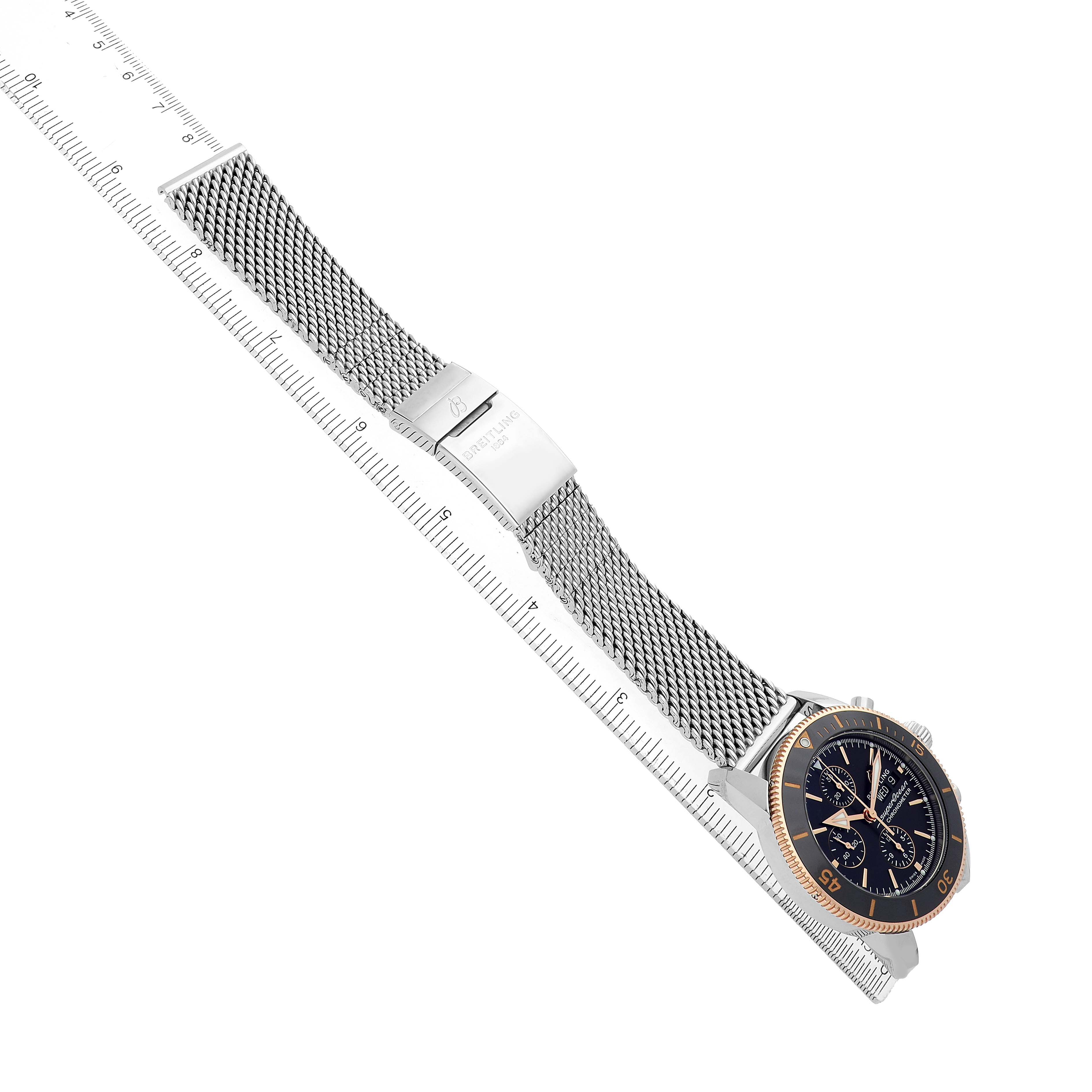 The Breitling Superocean U13313 Men's Stainless Steel Black Dial watch is displayed at an angle, showing the side and face, with a mesh bracelet and clasp visible.