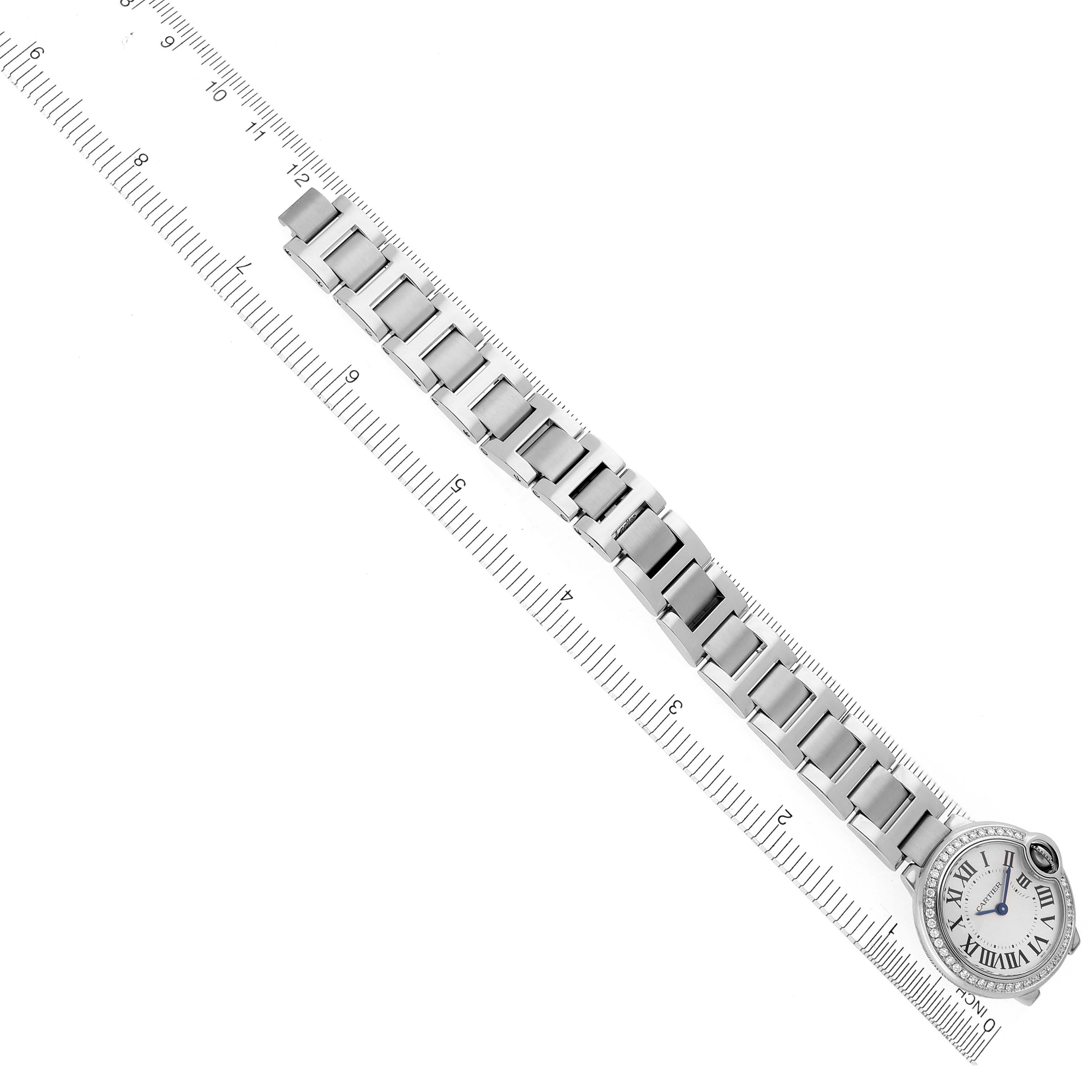 The Cartier Ballon Bleu W4BB0015 Women's Stainless Steel Silver Dial W4BB0015 Women's Stainless Steel Silver Dial watch is shown from a top-down angle, highlighting the face and metal bracelet against a ruler.