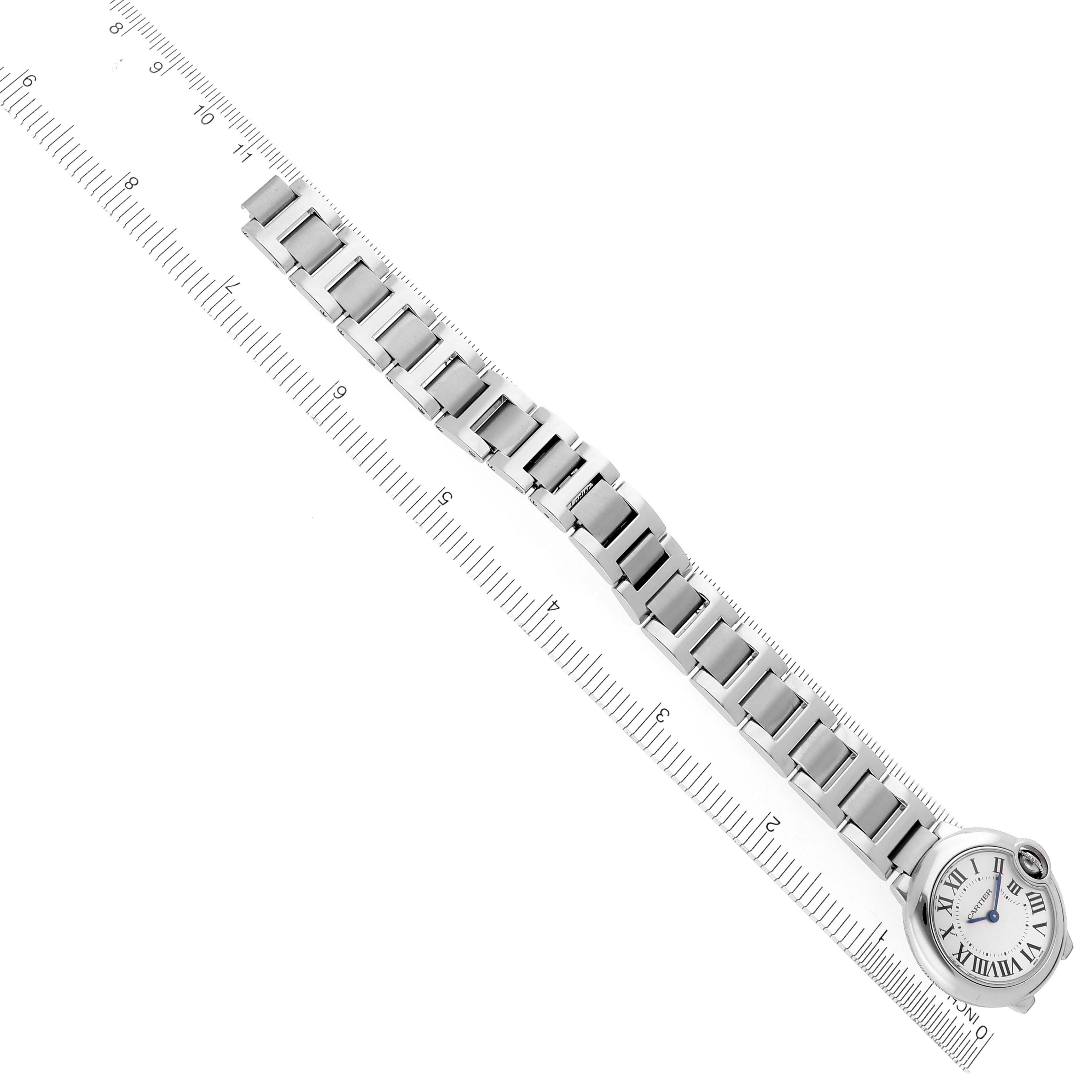The Cartier Ballon Bleu W69010Z4 Women
s Stainless Steel Silver Dial W69010Z4 Women
s Stainless Steel Silver Dial watch is shown from an overhead angle, highlighting its face and entire metal bracelet alongside a ruler.