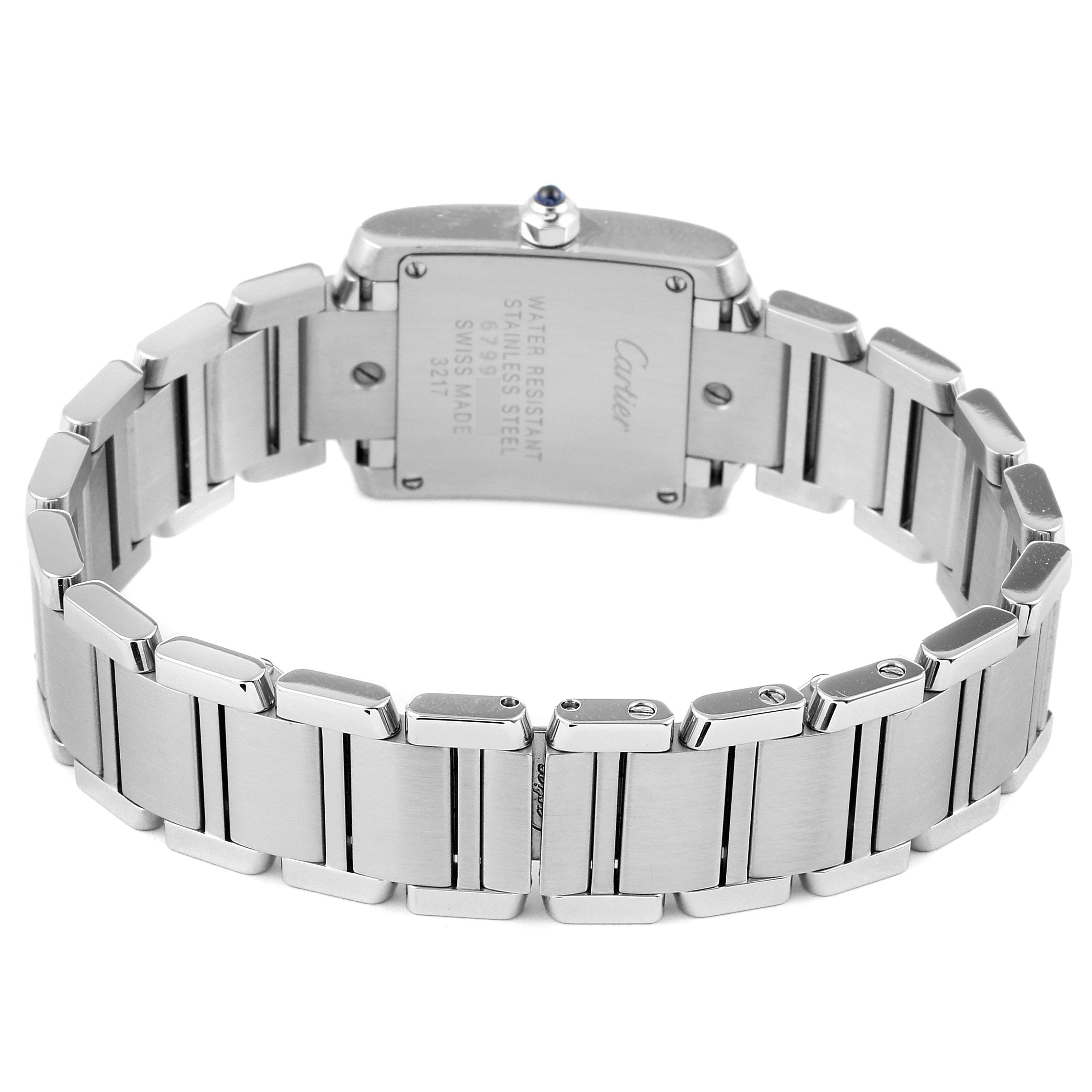 The image shows the back view of a Cartier Tank Française watch, highlighting the stainless steel bracelet and case back.
