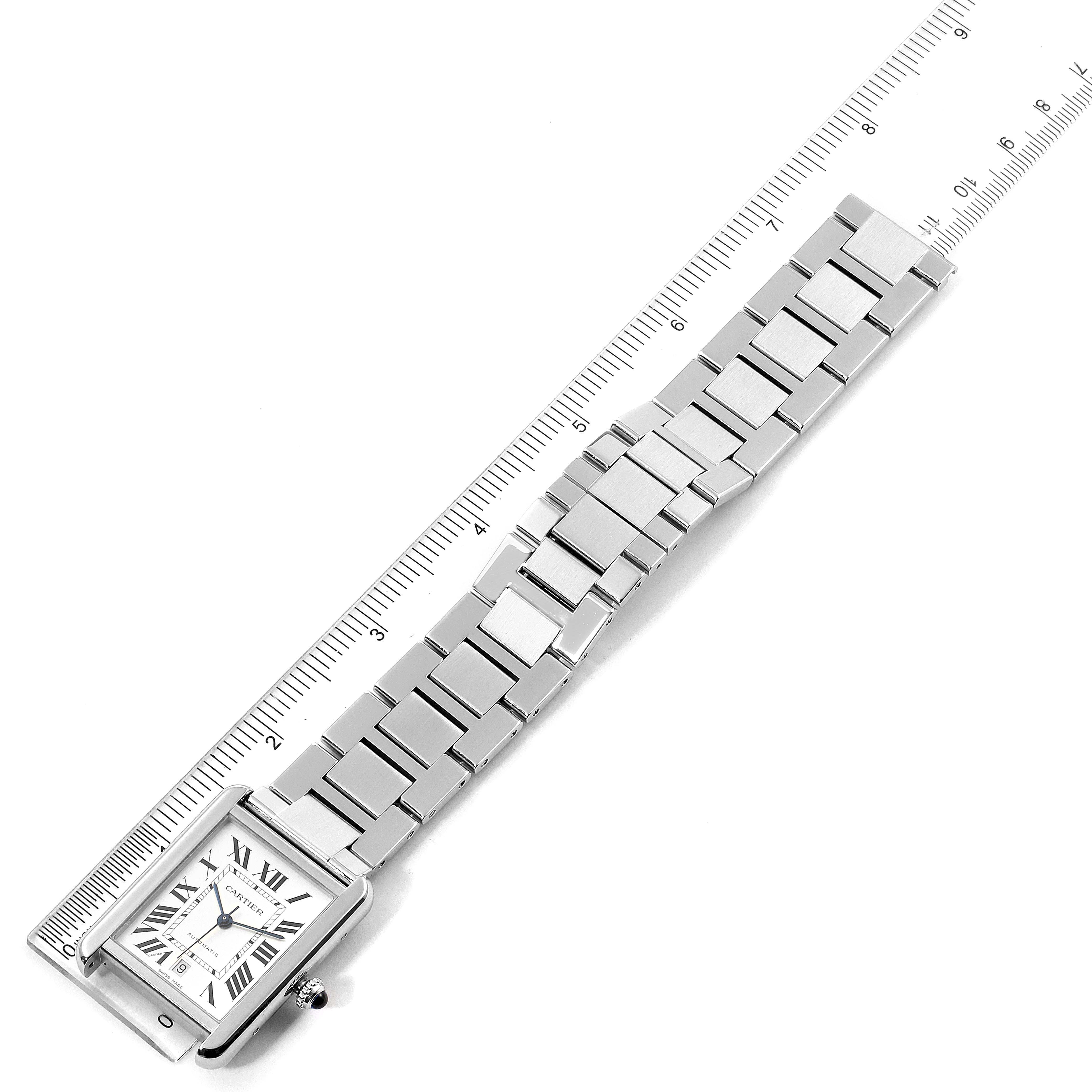 The image shows a Cartier Tank Solo W5200028 Men
s Stainless Steel Silver Dial W5200028 Men
s Stainless Steel Silver Dial watch laid flat against a ruler, displaying the face and metal bracelet from above.