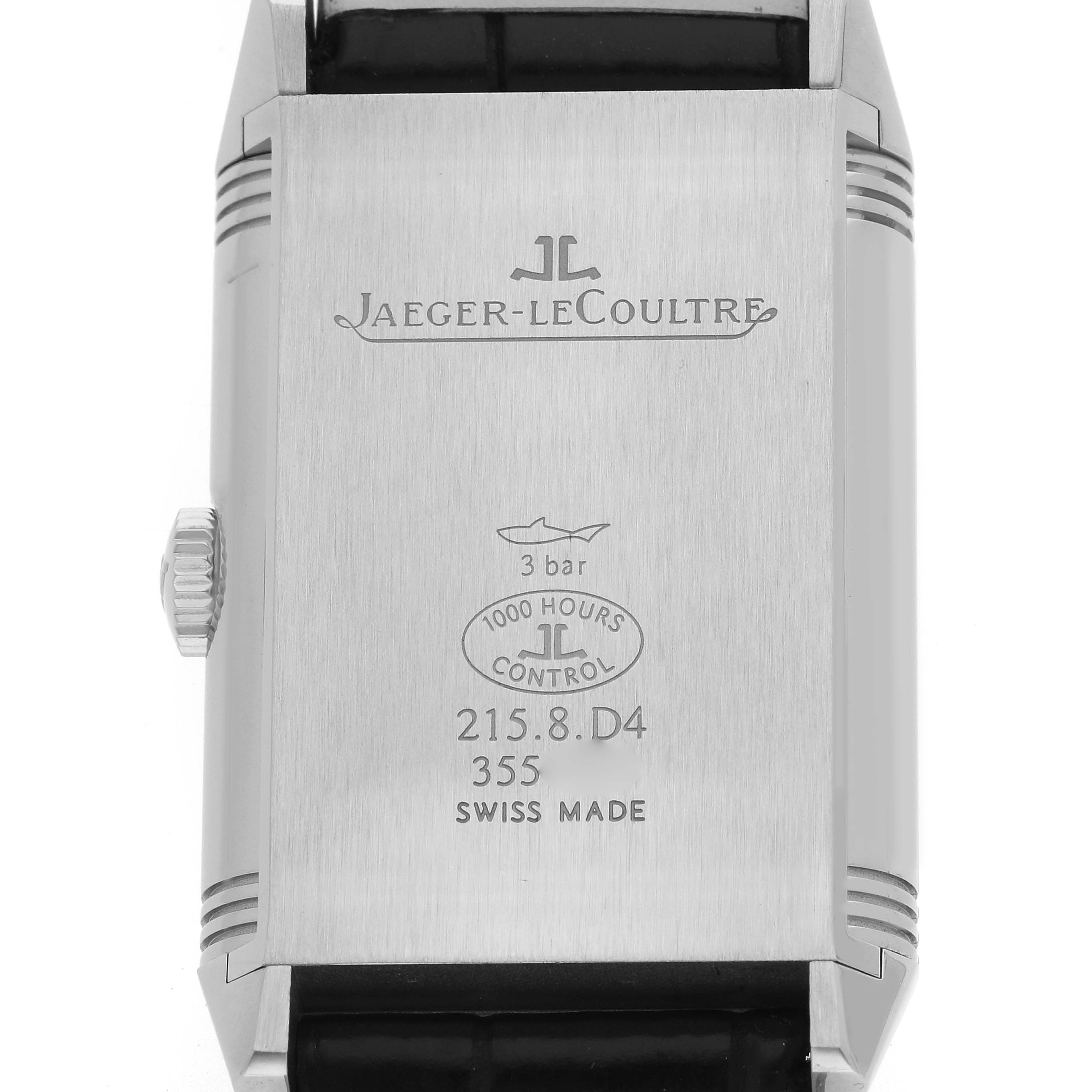 The image shows the back of the Jaeger-LeCoultre Reverso watch, displaying engraved branding, model details, and a crown on the side.