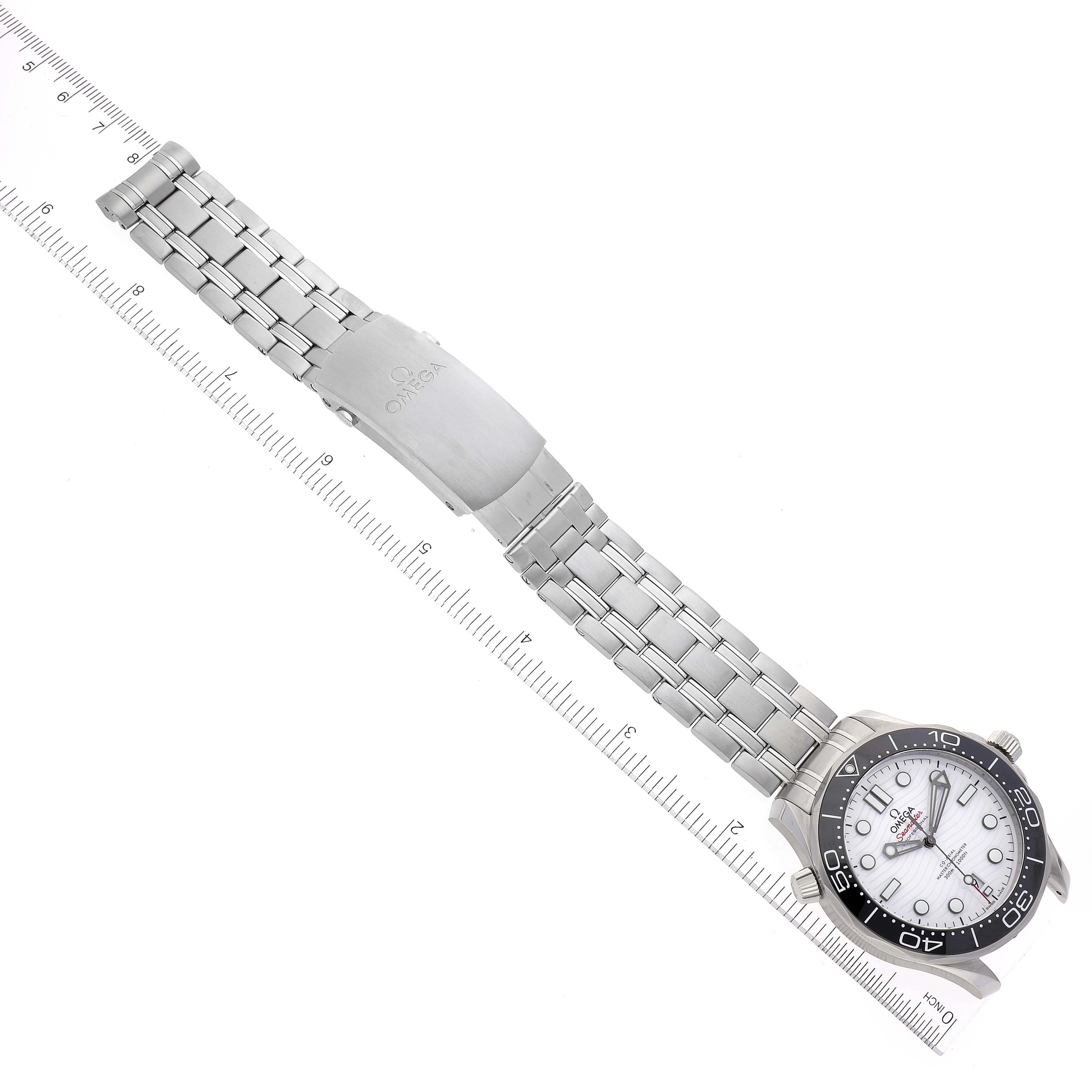 The image shows an Omega Seamaster 210.30.42.20.04.001 Men's Stainless Steel White Dial 210.30.42.20.04.001 Men's Stainless Steel White Dial watch positioned flat along a ruler, highlighting the stainless steel band, clasp, and watch face.