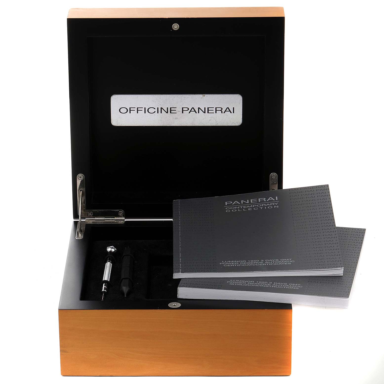 The image shows an open wooden box containing manuals and tools for the Luminor model by Panerai.