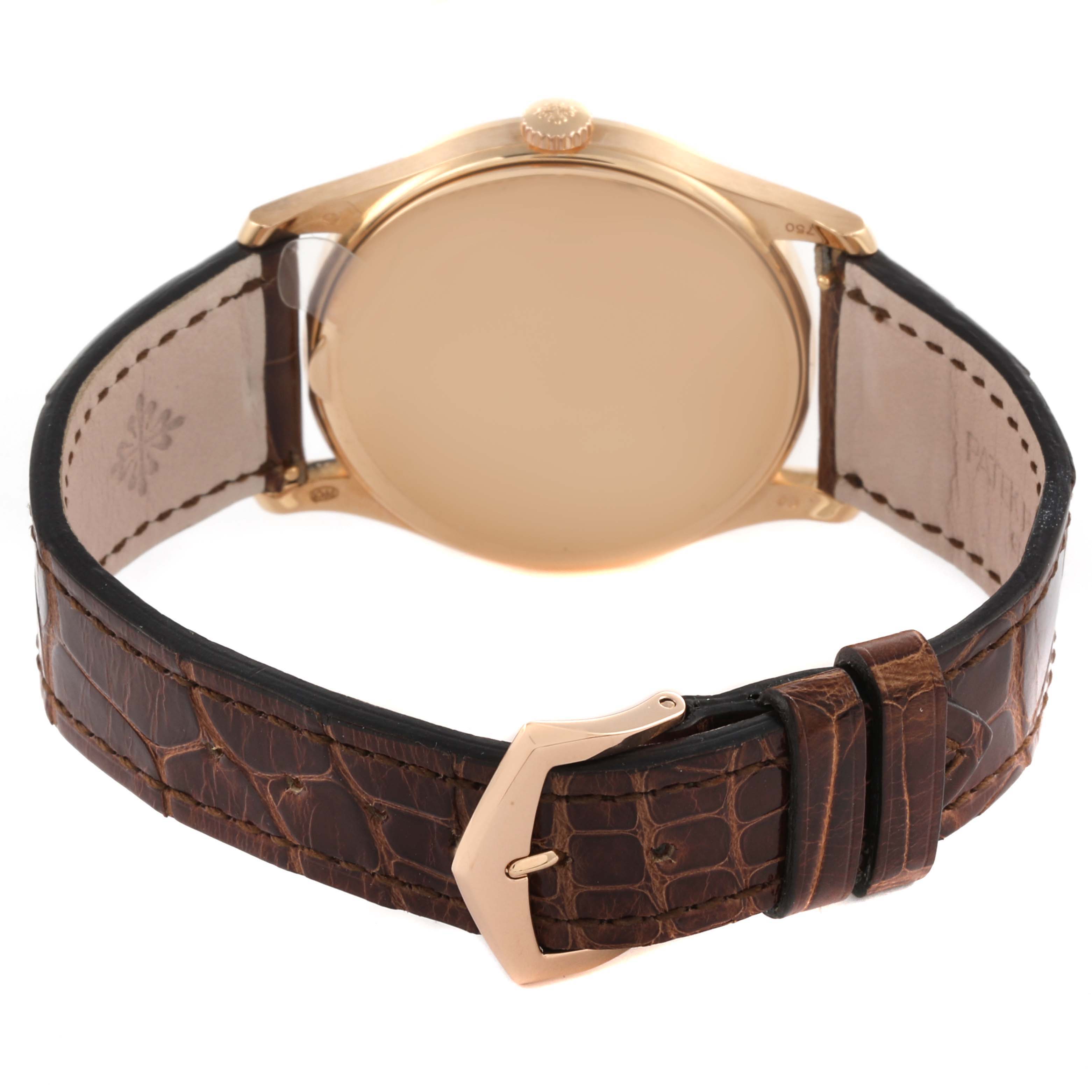 The image shows the back view of a Patek Philippe Calatrava 5196R-001 Men
s Rose Gold Silver Dial 5196R-001 Men
s Rose Gold Silver Dial watch, highlighting the case back, crown, and brown leather strap with clasp.