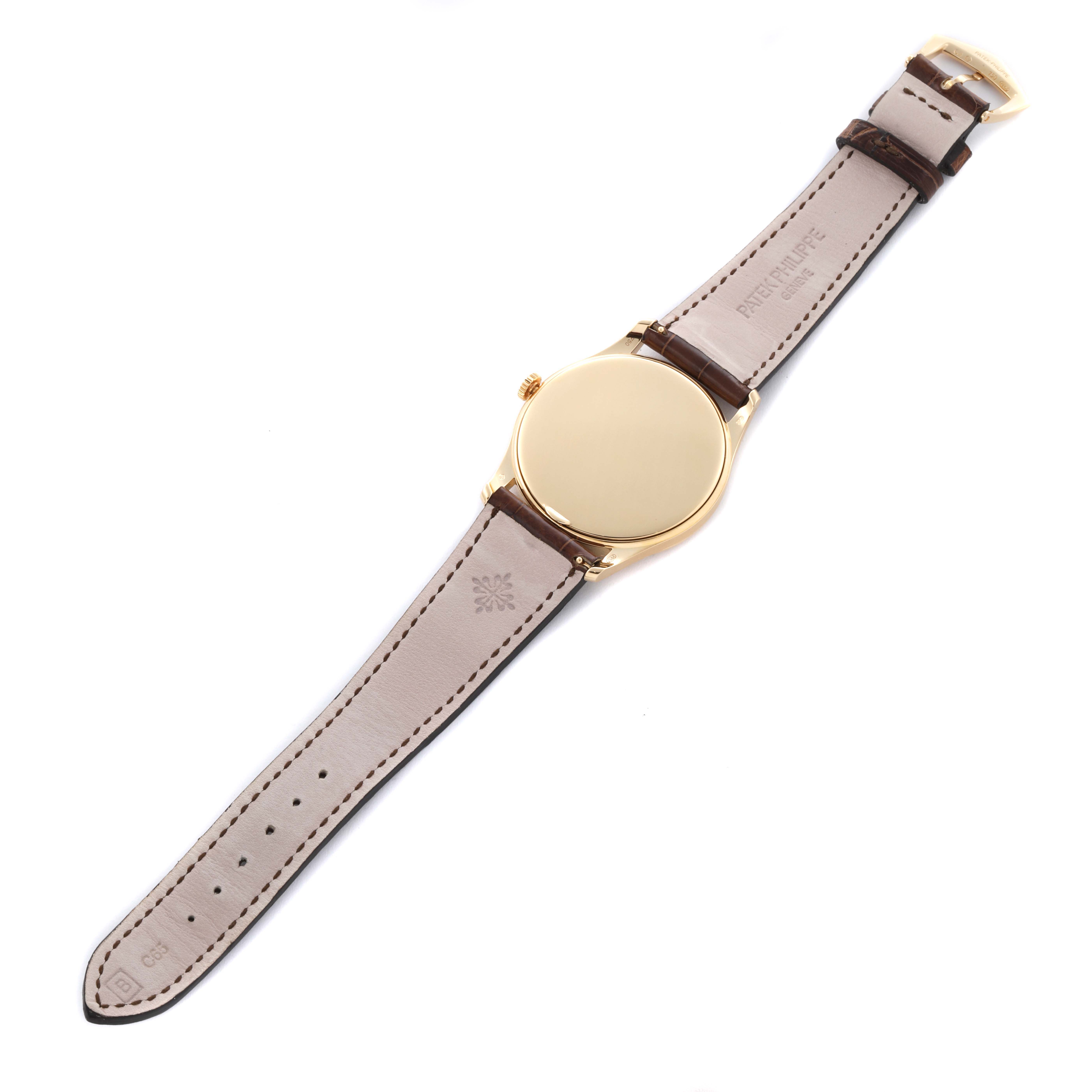 The Patek Philippe Calatrava 5196J Men's Yellow Gold Silver Dial 5196J Men's Yellow Gold Silver Dial watch is shown from the back, displaying the case back and leather strap.