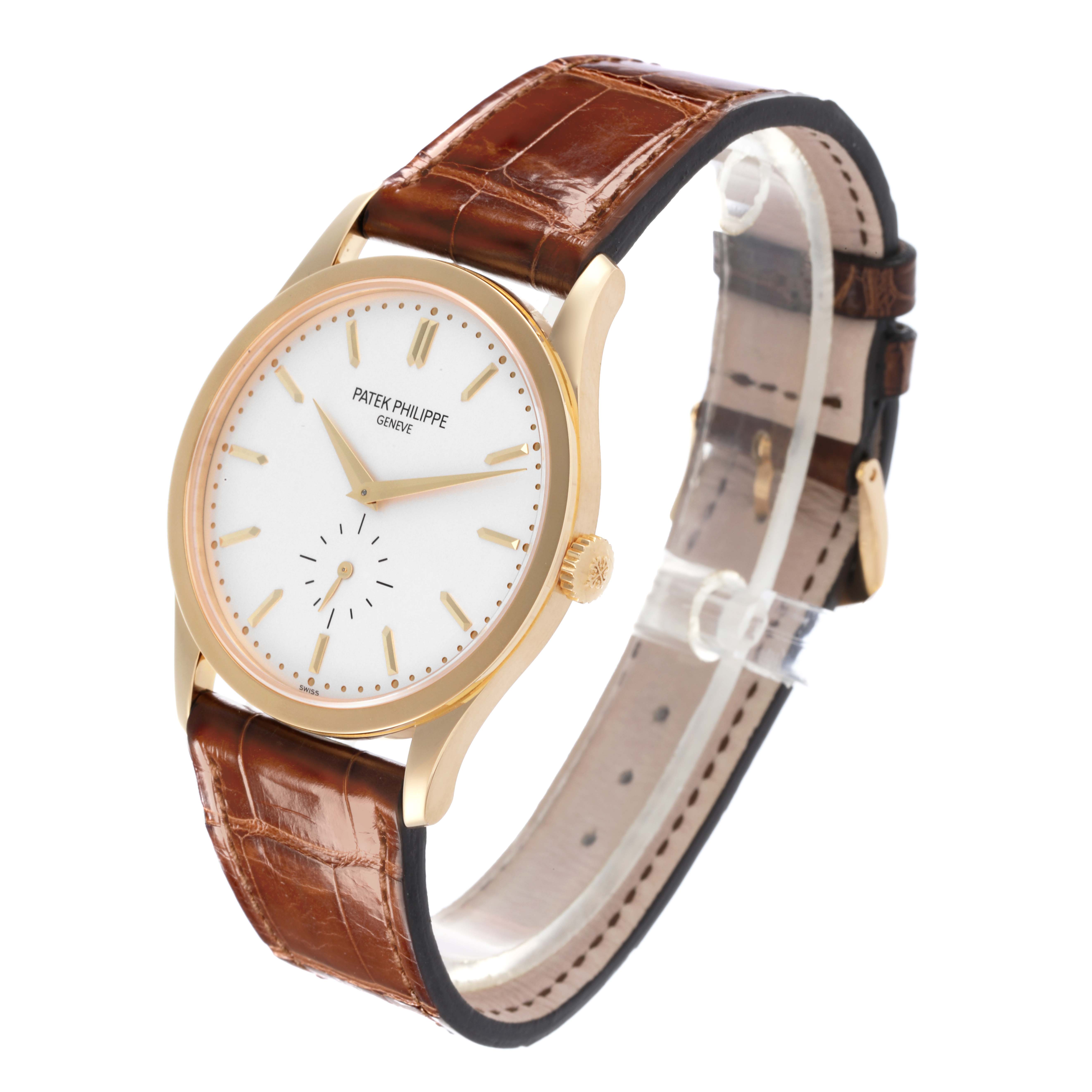 The Patek Philippe Calatrava 5196J Men's Yellow Gold Silver Dial 5196J Men's Yellow Gold Silver Dial watch is shown at a three-quarter angle, featuring the dial, case, crown, and leather strap.