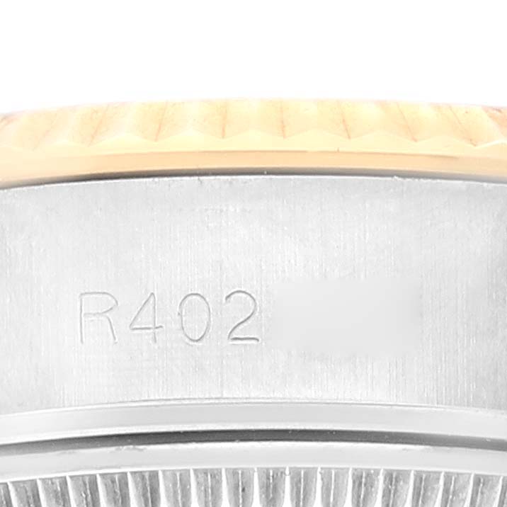 This close-up image of a Rolex Datejust 69173 Women's Steel and Gold (two tone) Champagne Dial 69173 Women's Steel and Gold (two tone) Champagne Dial watch shows the side of the case with engraved serial numbers.