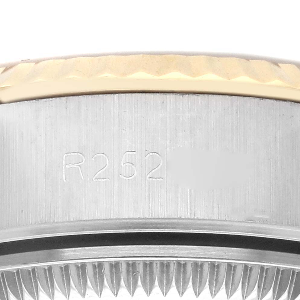 The image shows a close-up of the side of a Rolex Datejust 69173 Women's Steel and Gold (two tone) Silver Dial 69173 Women's Steel and Gold (two tone) Silver Dial, focusing on the bezel and case with engraved markings.