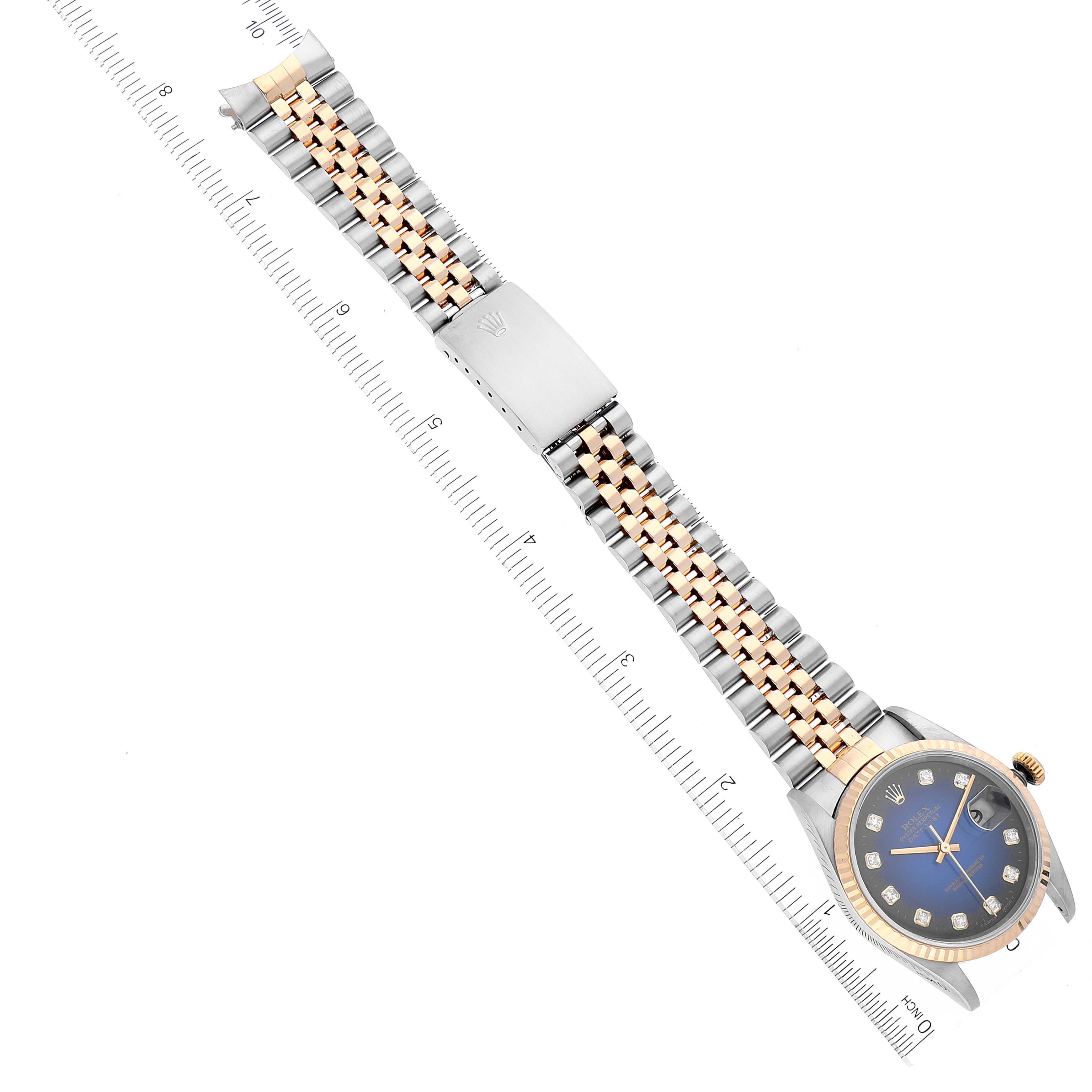 The image shows a Rolex Datejust 16233 Men's Steel and Gold (two tone) Blue Dial 16233 Men's Steel and Gold (two tone) Blue Dial watch laid flat, highlighting the bracelet, clasp, and watch face with rulers for scale.