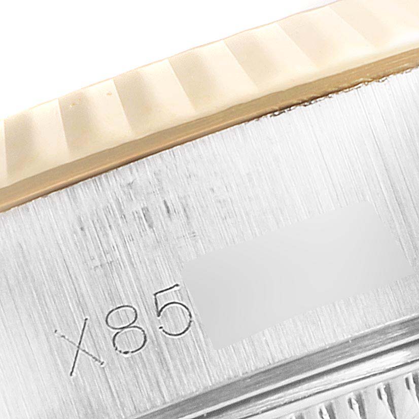 The image shows a close-up of the Rolex Datejust 69173 Women's Steel and Gold (two tone) White Dial 69173 Women's Steel and Gold (two tone) White Dial watch edge, revealing part of the bezel and serial engraving.