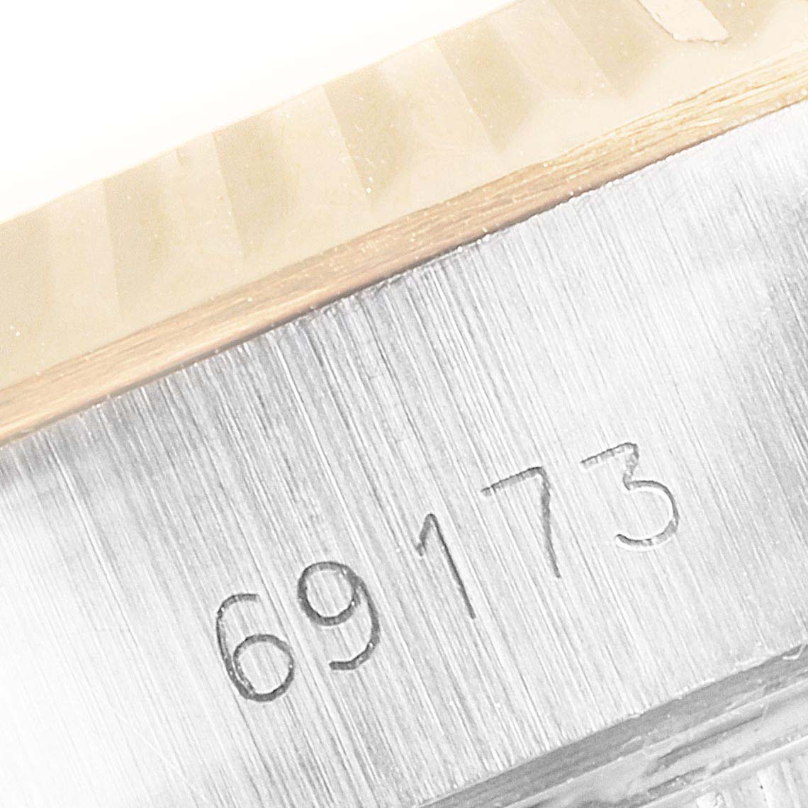 This close-up image of a Rolex Datejust 69173 Women's Steel and Gold (two tone) White Dial 69173 Women's Steel and Gold (two tone) White Dial model shows the engraved model number 69173 and part of the fluted bezel.