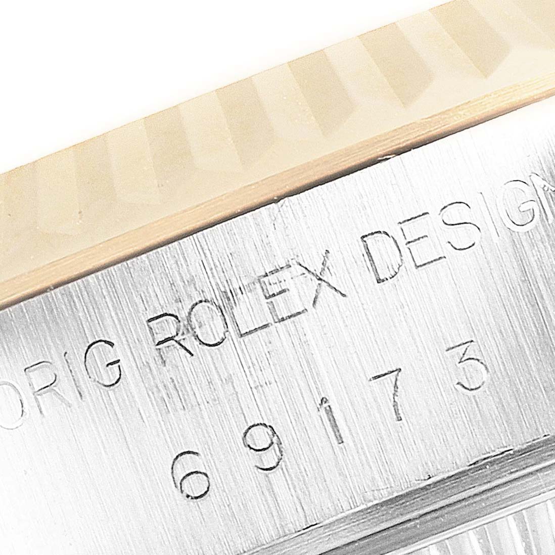 The image shows a close-up of the serial number and fluted bezel on a Rolex Datejust 69173 Women's Steel and Gold (two tone) White Dial 69173 Women's Steel and Gold (two tone) White Dial watch.