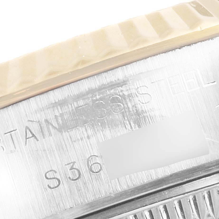 This close-up shows part of the stainless steel casing and fluted bezel of a Rolex Datejust 69173 Women's Steel and Gold (two tone) White Dial 69173 Women's Steel and Gold (two tone) White Dial watch.