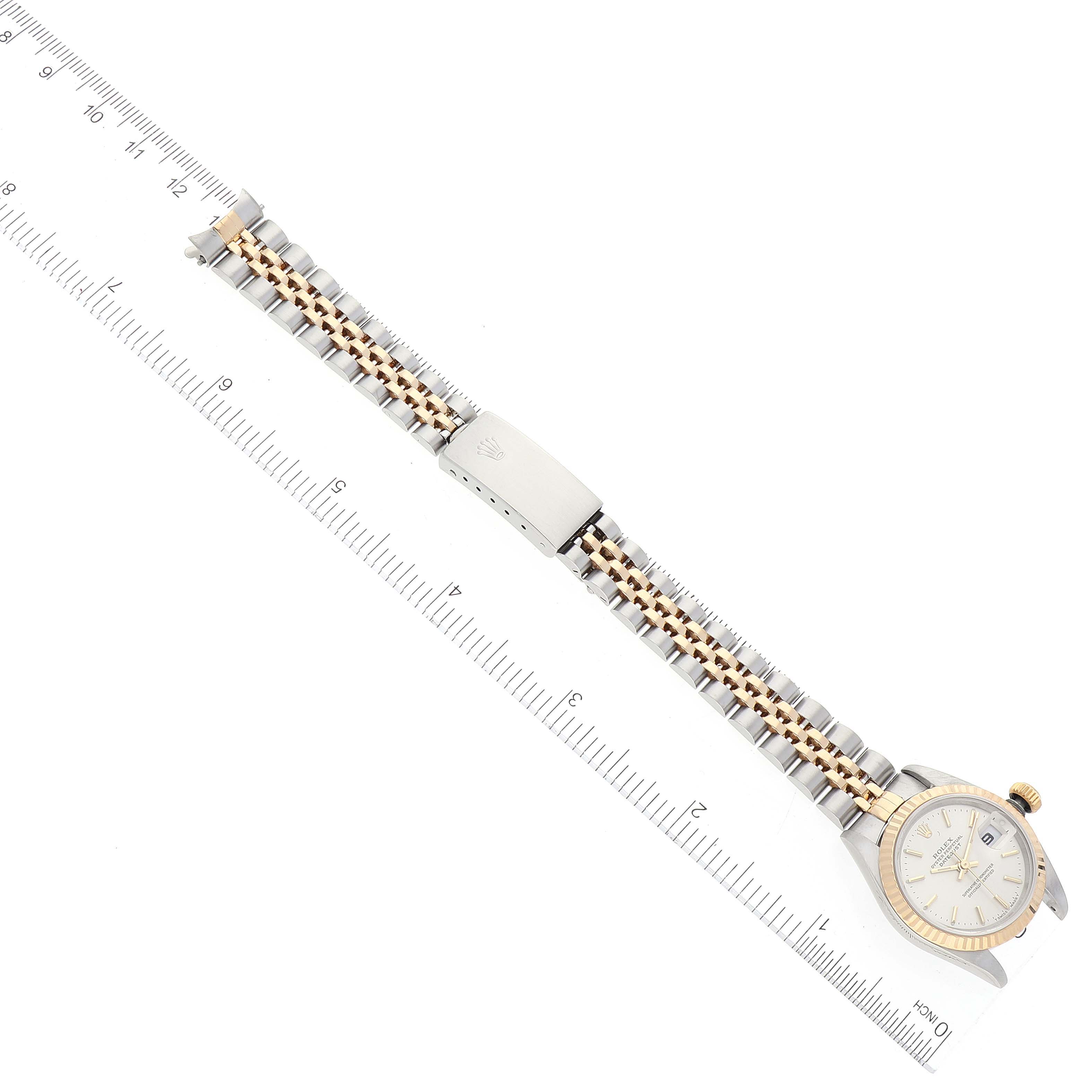 The image shows a Rolex Datejust 79173 Women's Steel and Gold (two tone) Silver Dial 79173 Women's Steel and Gold (two tone) Silver Dial watch laying flat with its full bracelet and clasp visible alongside a ruler for scale.