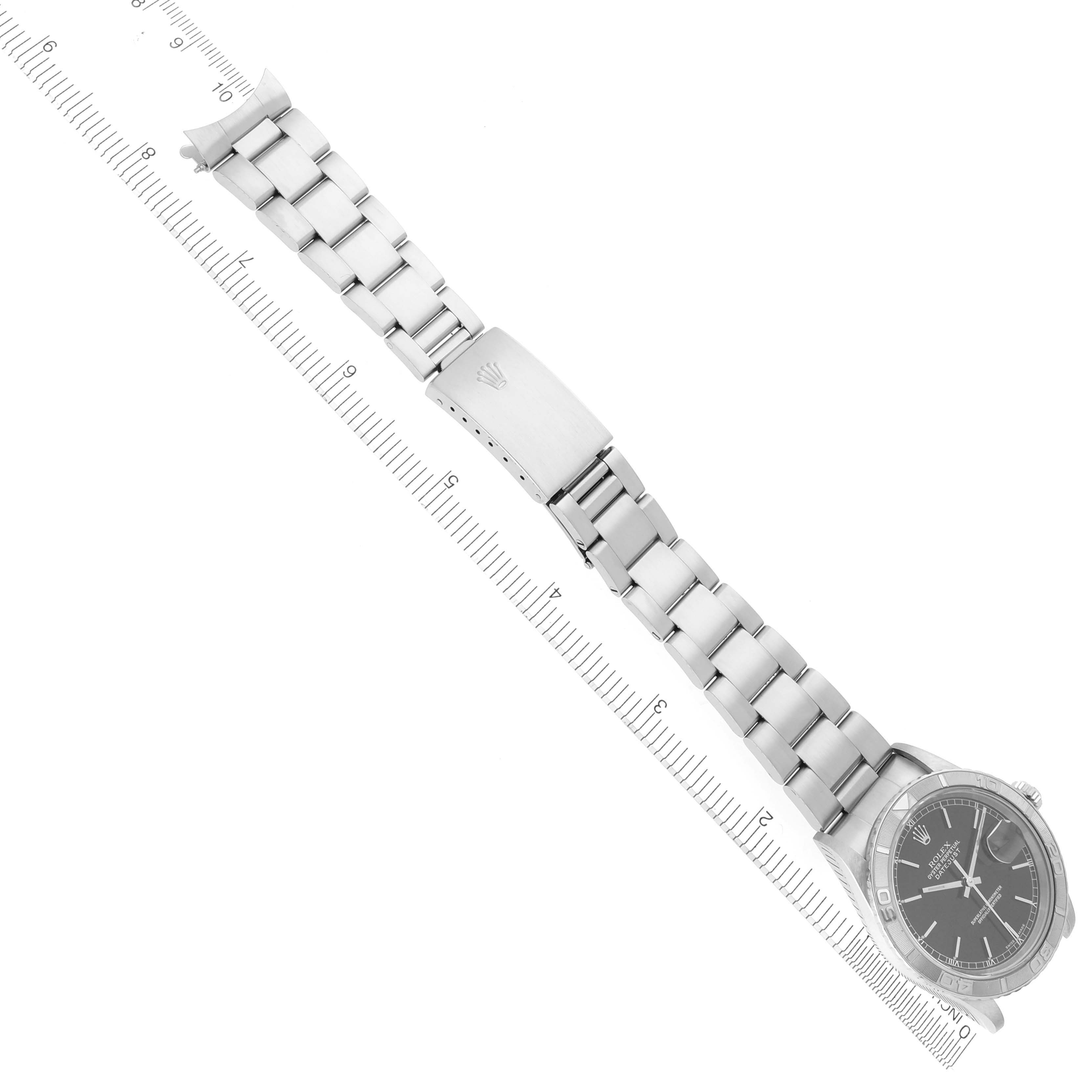 The Rolex Turn-o-Graph 16264 Men's Stainless Steel Black Dial 16264 Men's Stainless Steel Black Dial watch is shown from a top-down angle, displaying the bracelet and clasp parallel to a ruler.