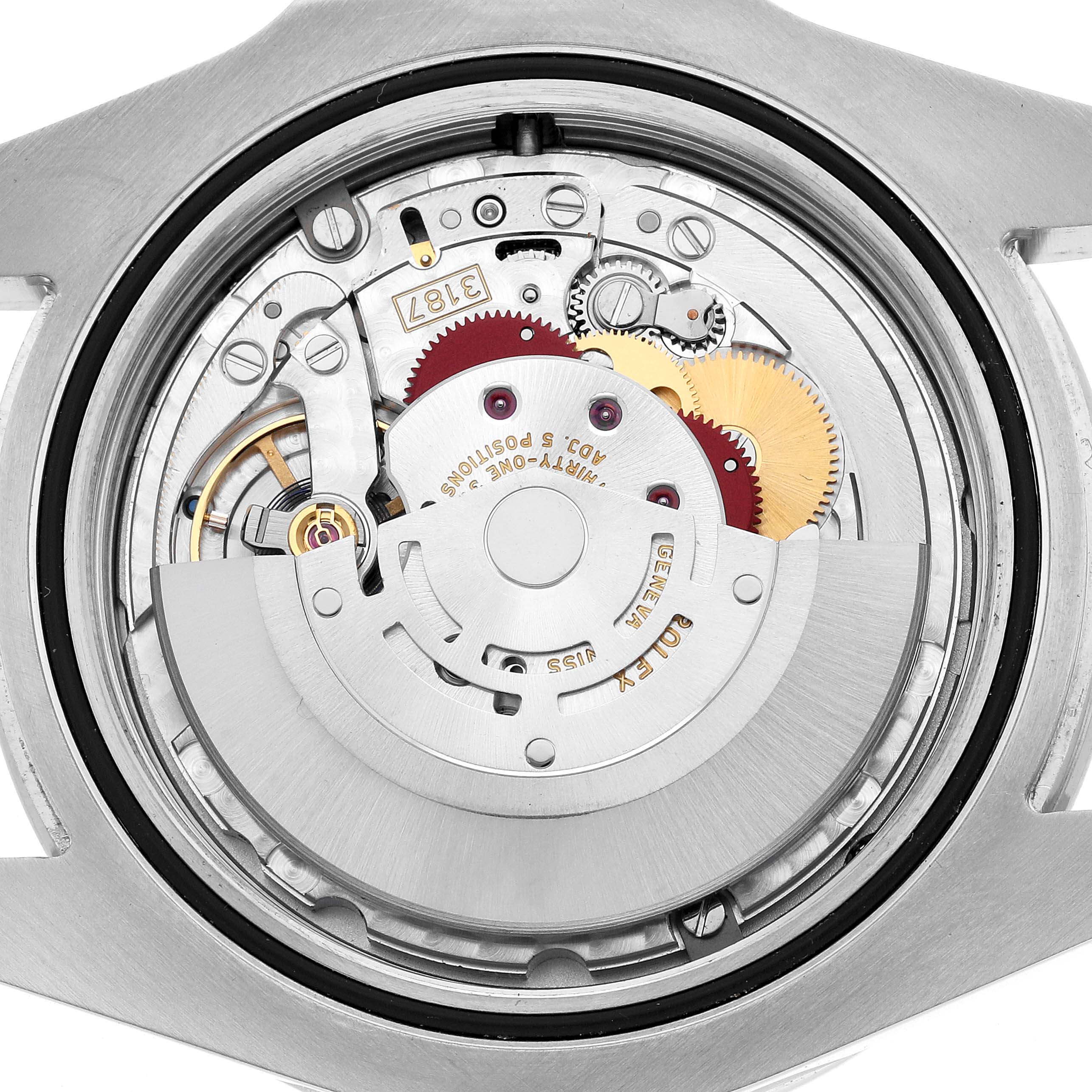 The image shows the inner mechanical movement of a Rolex Explorer 216570 Men's Stainless Steel White Dial watch, viewed from the back with visible gears and rotor.