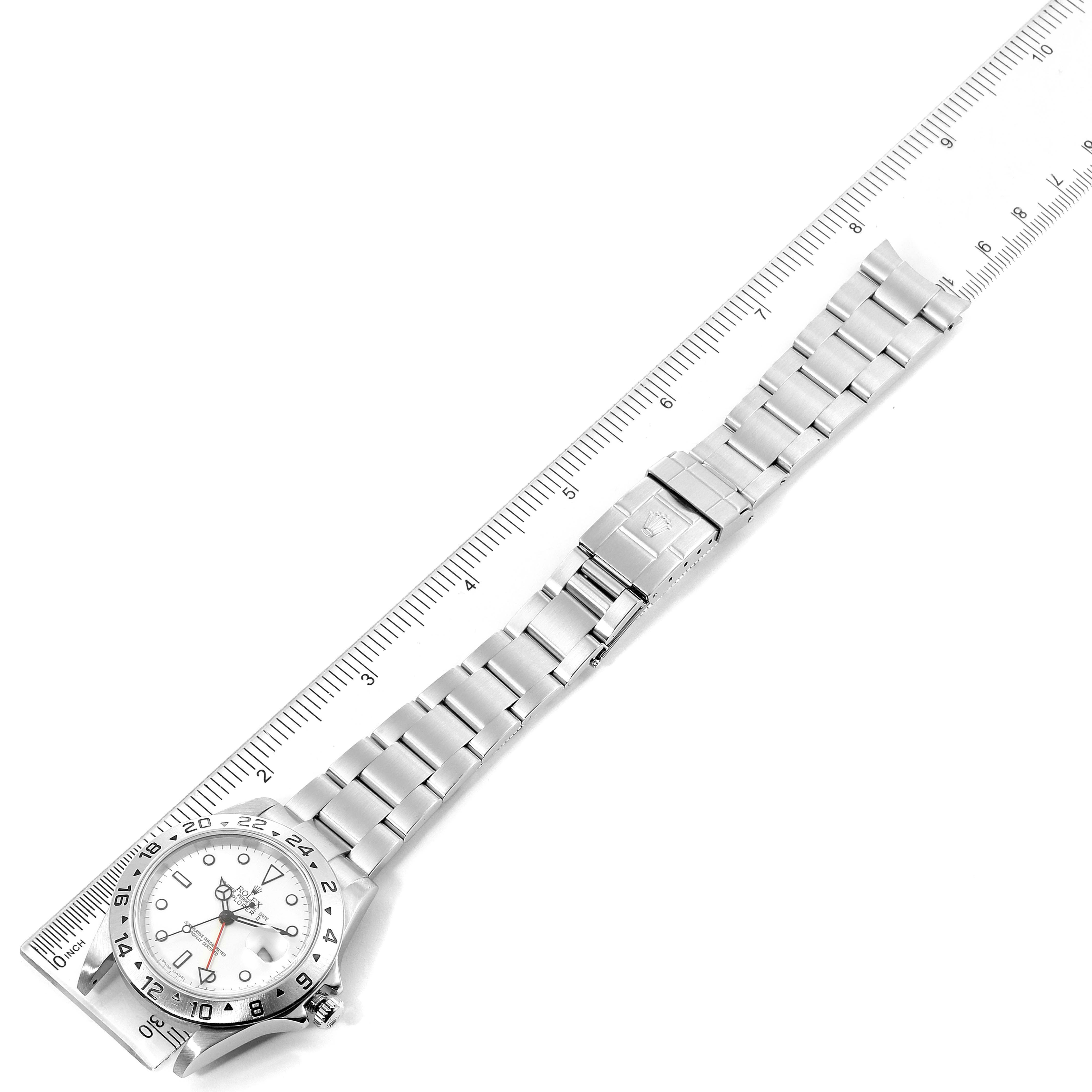 The image shows a Rolex Explorer 16570 Men
s Stainless Steel White Dial 16570 Men
s Stainless Steel White Dial model watch laid flat, with a ruler placed alongside it for measurement.