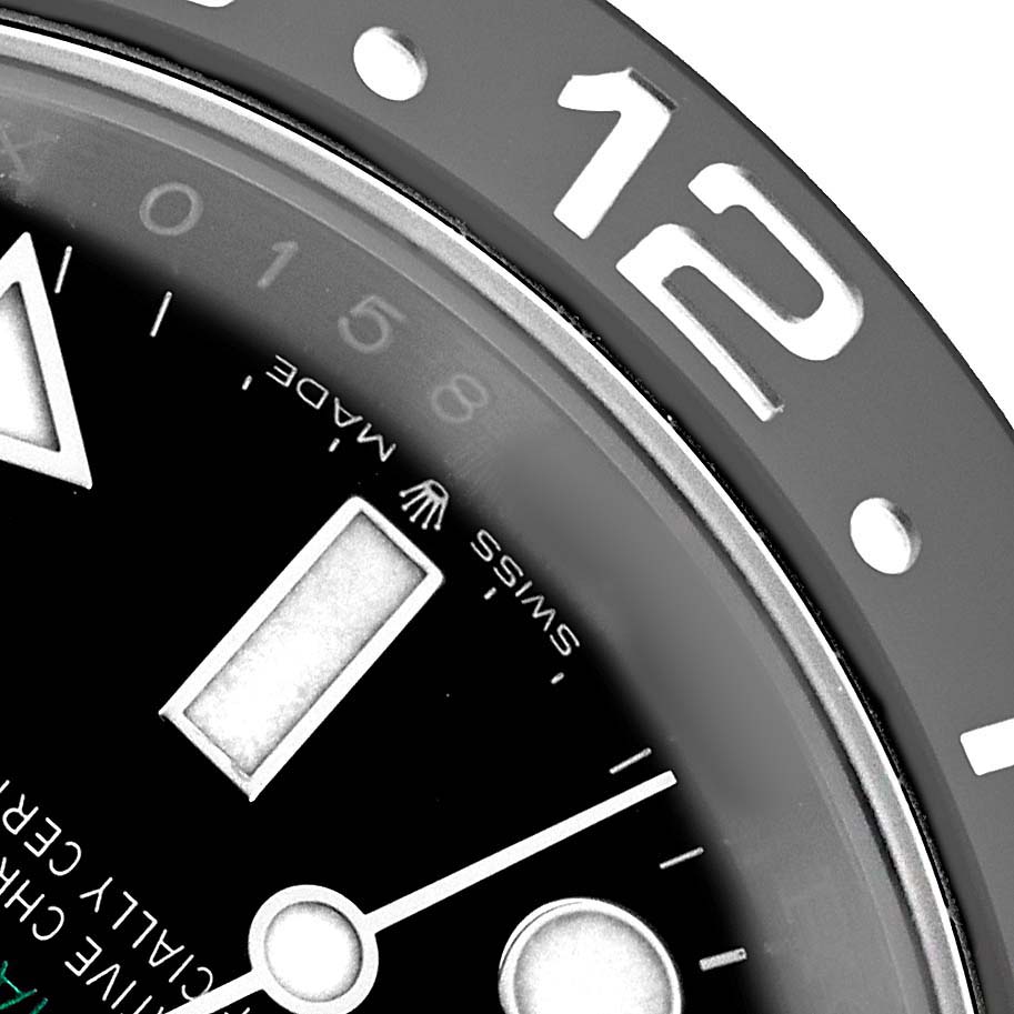 The image shows a close-up of the bezel and dial on the Rolex GMT-Master 126710 Men's Stainless Steel Black Dial watch, highlighting the 12 marker and part of the minute hand.