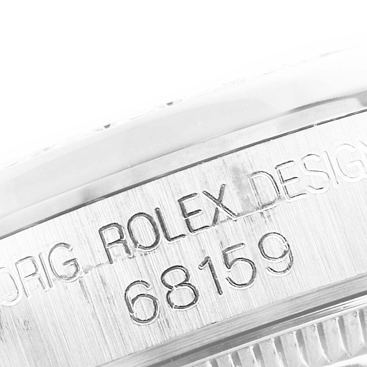The image shows a close-up view of the side of a Rolex President 68159 Women's White Gold Silver Dial 68159 Women's White Gold Silver Dial model watch, featuring its serial number and design engraving.