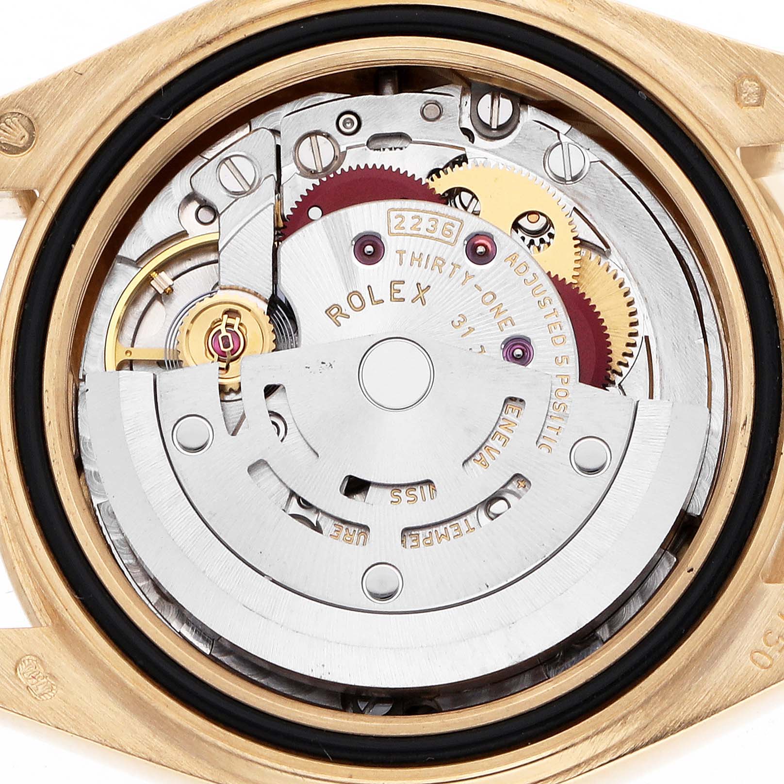 The image shows the movement of a Rolex President 279138 Women's Yellow Gold Champagne Dial watch from a back angle, displaying gears and intricate components.
