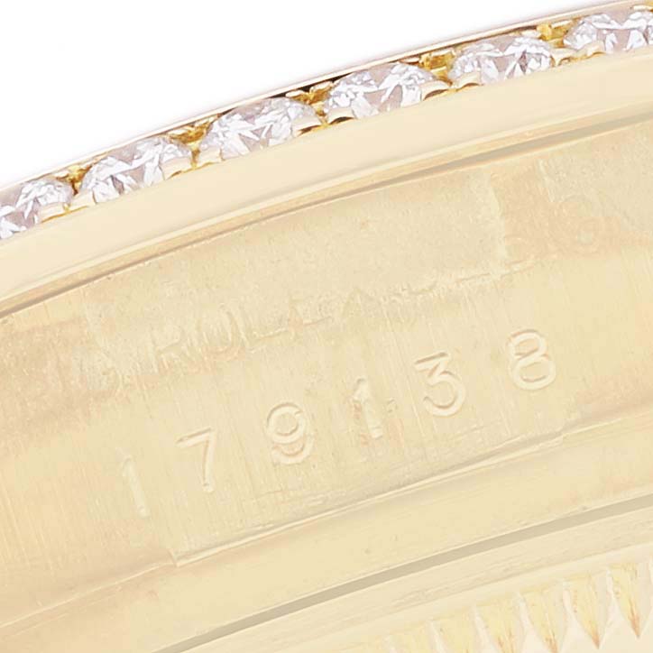 The image shows a close-up of the Rolex President 179138 Women's Yellow Gold Mother of Pearl Dial model's bezel with diamonds and part of its serial number.