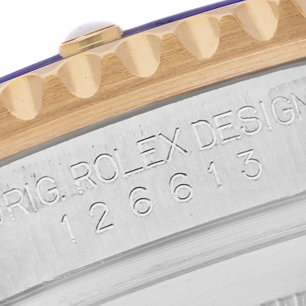 The image shows a close-up of the Rolex Submariner 126613LB Men's Steel and Gold (two tone) Blue Dial 126613LB Men's Steel and Gold (two tone) Blue Dial's engraved case edge and part of the gold bezel.