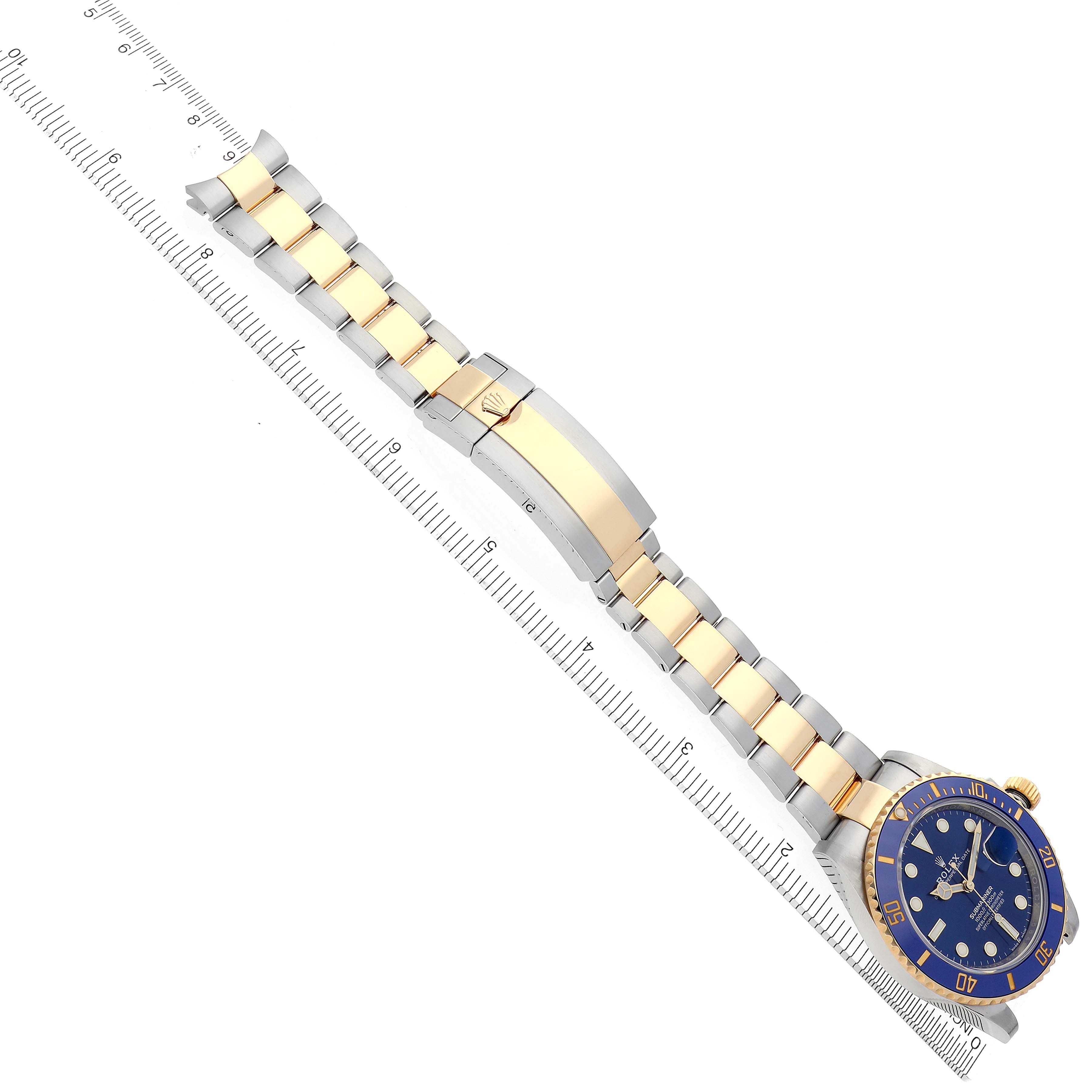 The image shows a side view of a Rolex Submariner 126613LB Men's Steel and Gold (two tone) Blue Dial 126613LB Men's Steel and Gold (two tone) Blue Dial with a two-tone bracelet and clasp, positioned next to a ruler for scale.
