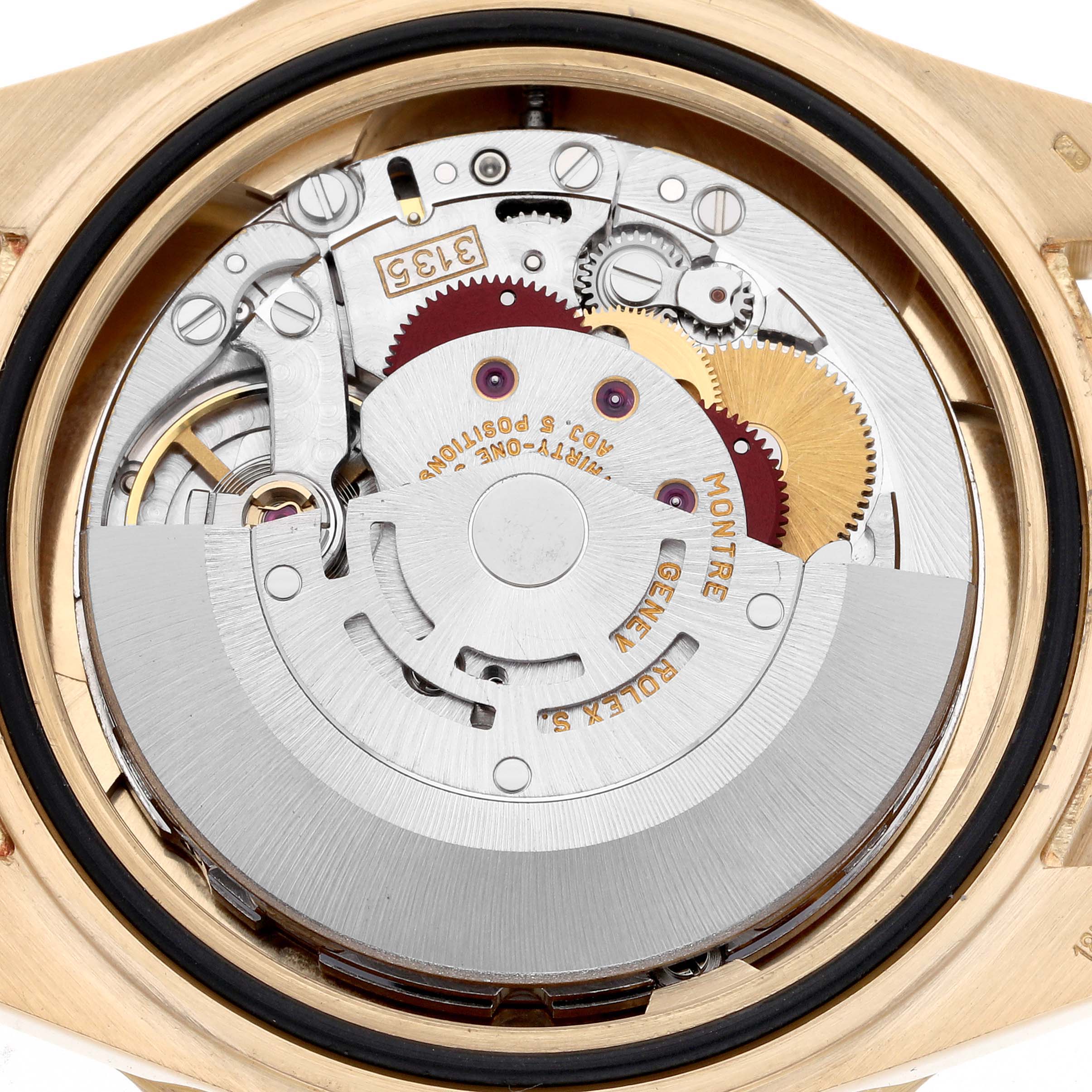 The image shows the exposed movement of a Rolex Submariner 16618 Men
s Yellow Gold Black Dial 16618 Men
s Yellow Gold Black Dial, highlighting gears and the rotor from a rear angle.