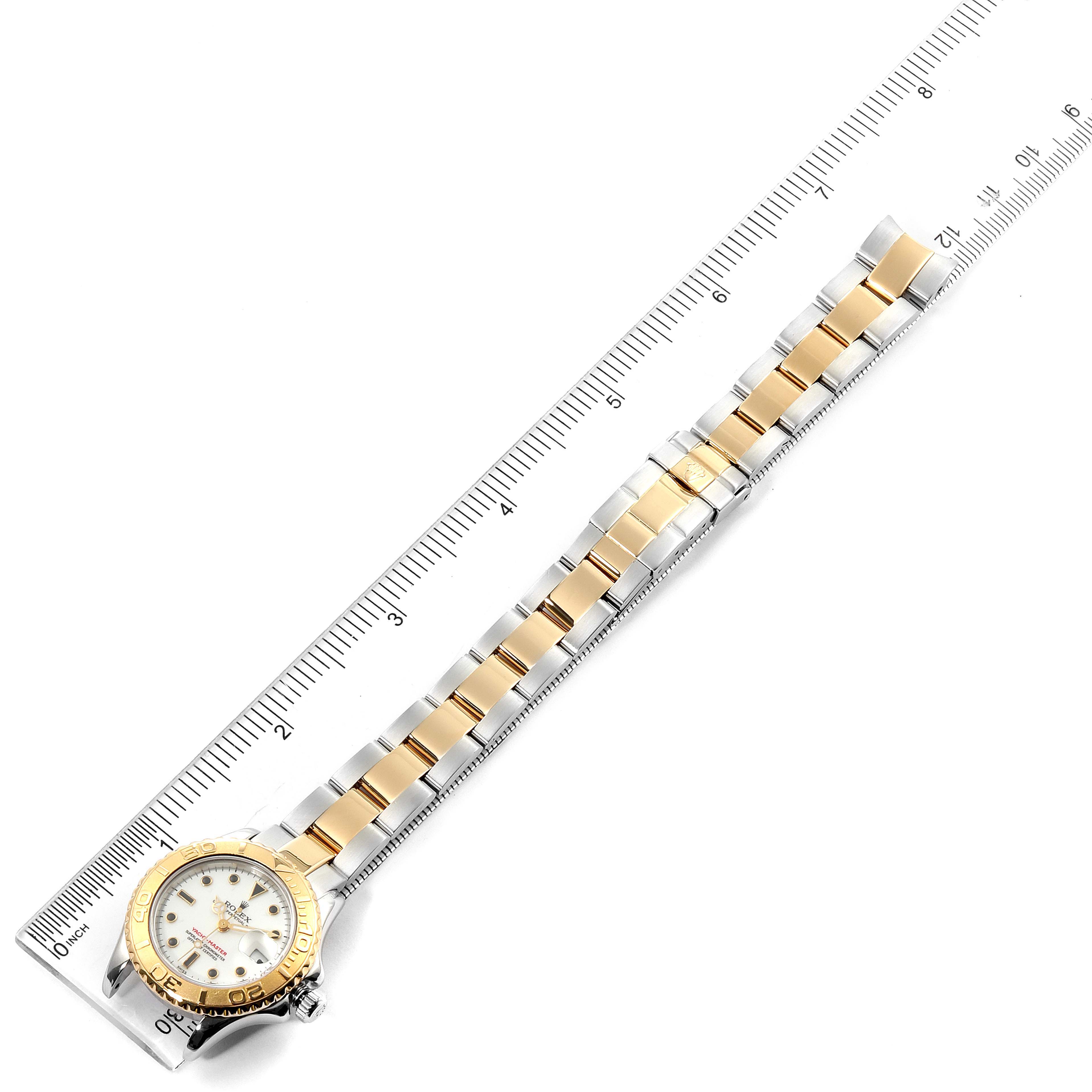 The image shows a Rolex Yacht-Master 169623 Women
s Steel and Gold (two tone) White Dial 169623 Women
s Steel and Gold (two tone) White Dial watch from a top-down angle, featuring the band and part of the watch face, measured alongside a ruler.