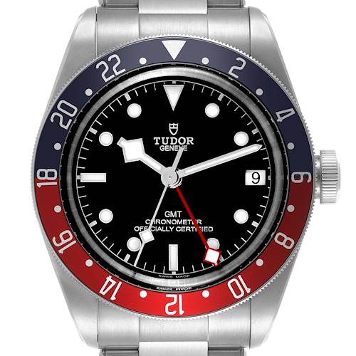 The Tudor Heritage Black Bay watch is shown from a front angle, displaying the dial, bezel, and part of the bracelet.