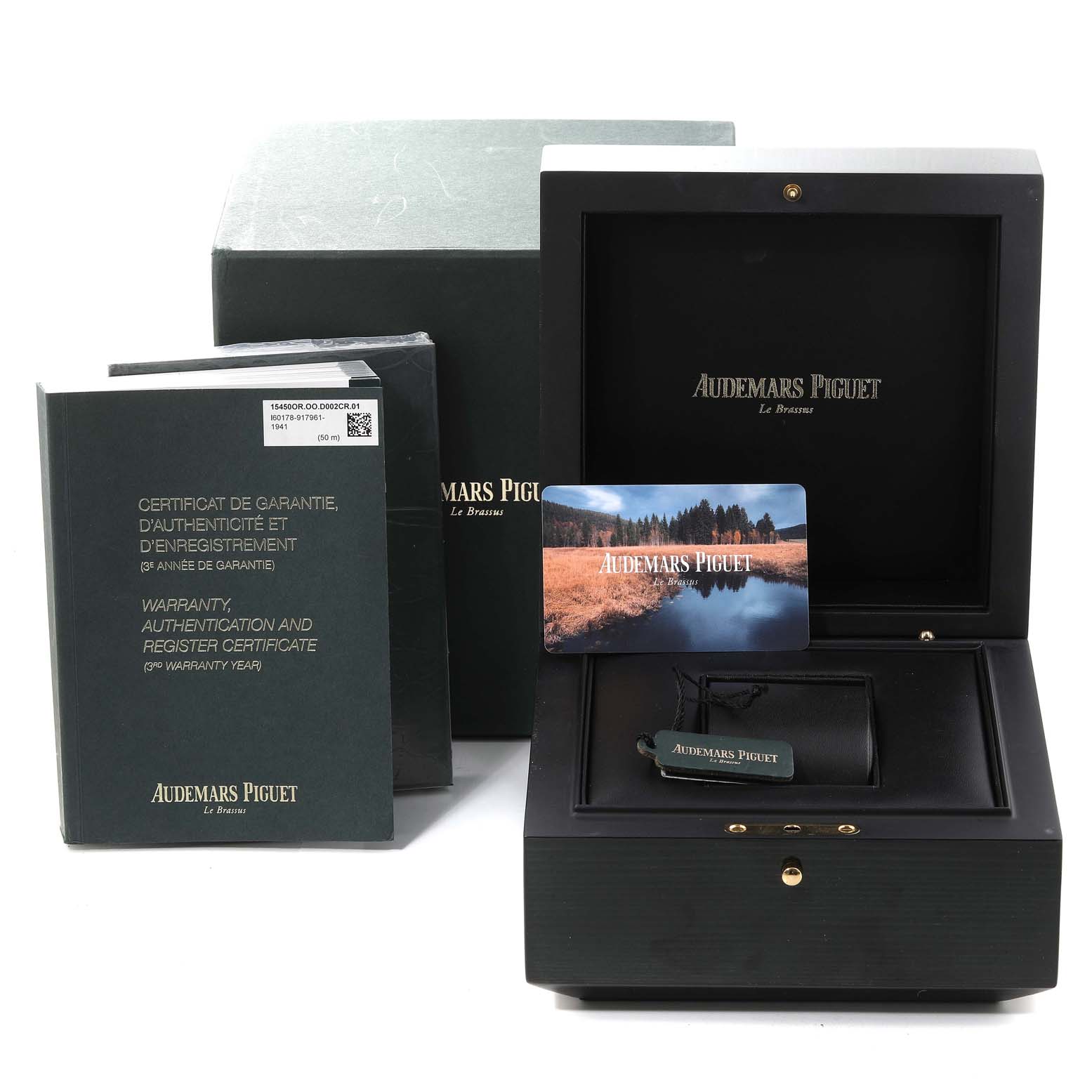 The image shows a Royal Oak model by Audemars Piguet packaging accessories: a box, warranty cards, and booklets.