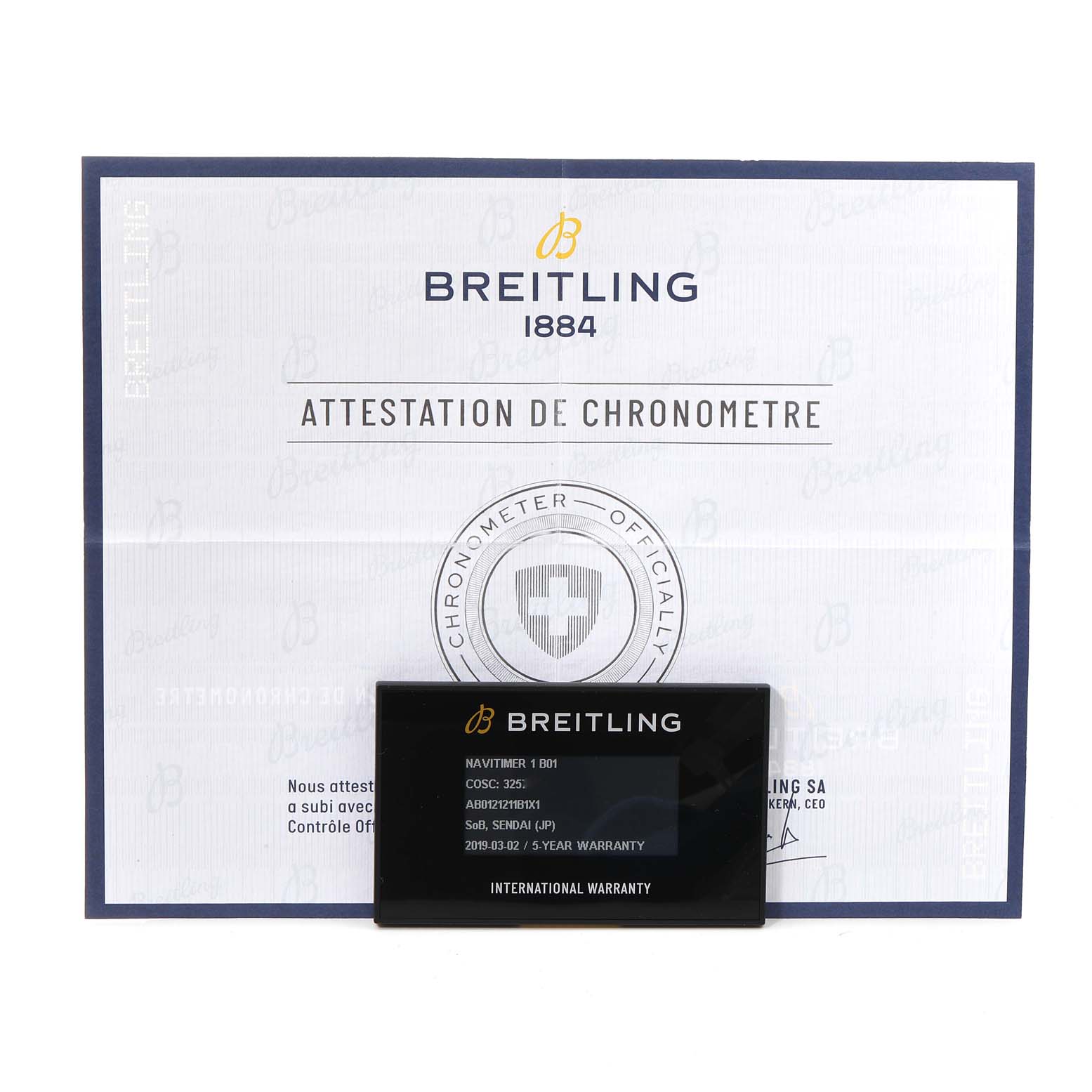 The image shows the Breitling Navitimer AB0121 Men
s Stainless Steel Black Dial AB0121 Men
s Stainless Steel Black Dial model’s warranty card and certificate at a front angle.