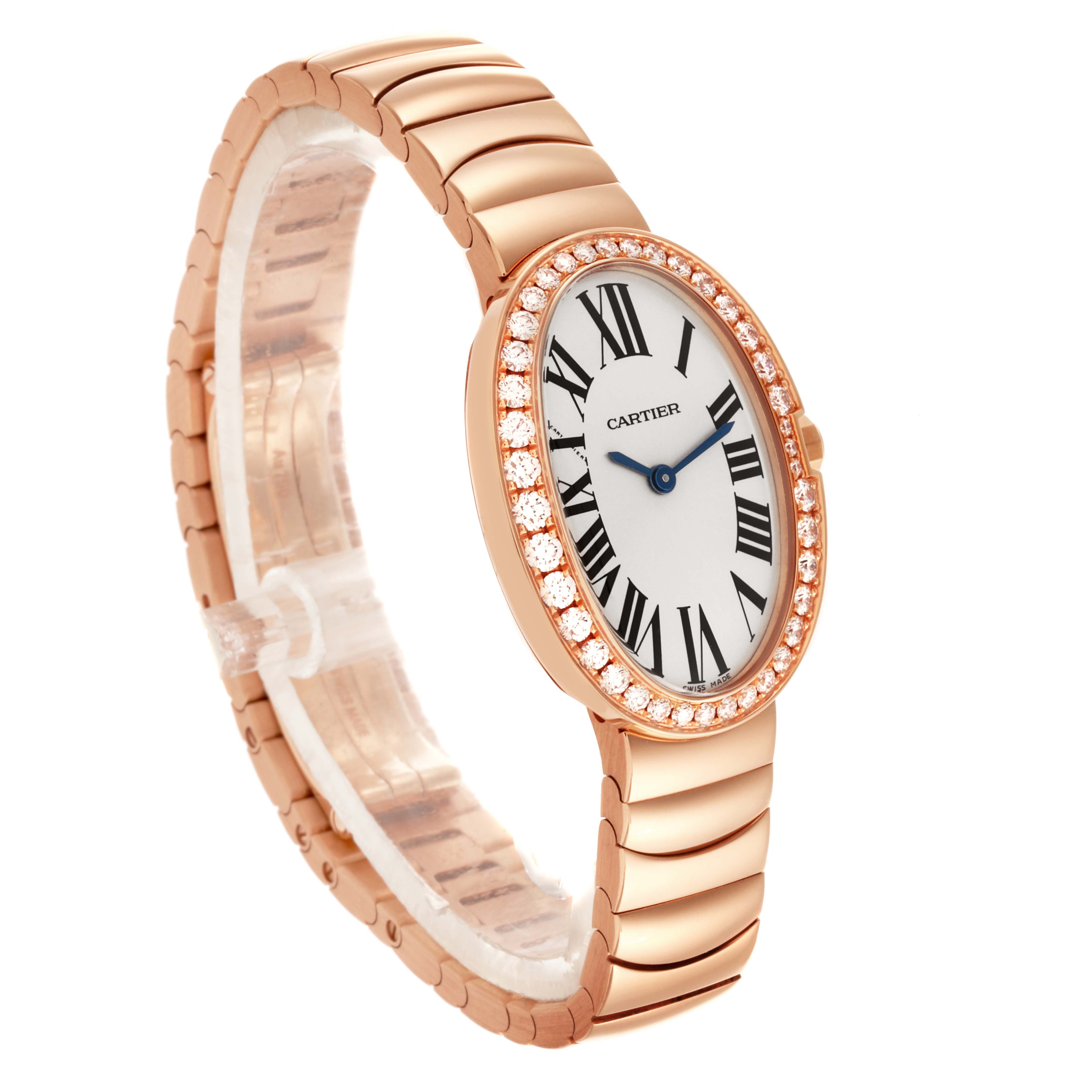The Cartier Baignoire WB520002 Women
s Rose Gold Silver Dial WB520002 Women
s Rose Gold Silver Dial watch is shown at a three-quarter angle, highlighting its oval face, diamond bezel, and gold bracelet.