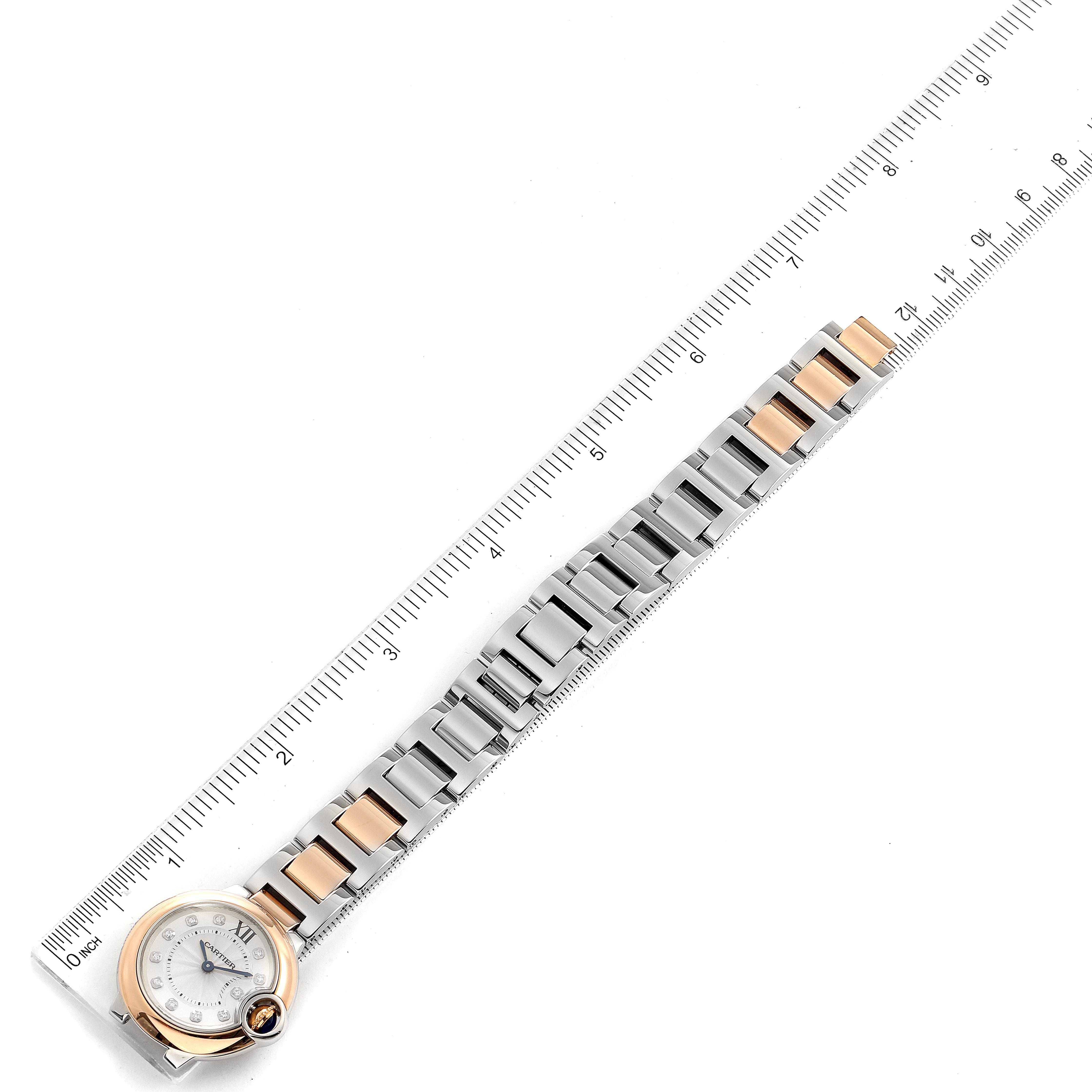 The image shows a top-down view of a Cartier Ballon Bleu W3BB0005 Women's Steel and Gold (two tone) Silver Dial W3BB0005 Women's Steel and Gold (two tone) Silver Dial watch with a two-tone metal bracelet and a ruler beside it.