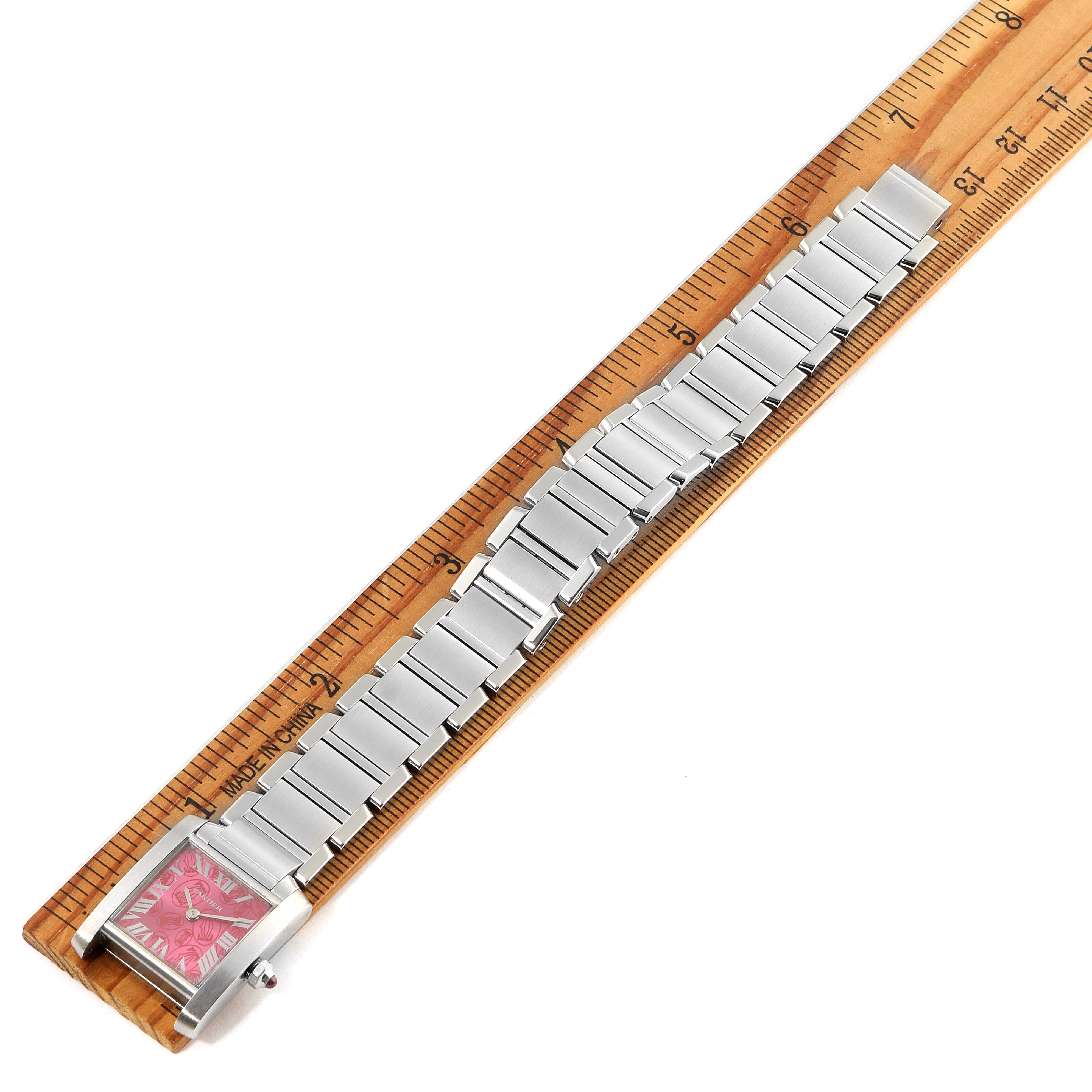The Tank Francaise by Cartier is displayed at an angle showcasing its full length along a ruler, highlighting the watch face and bracelet.