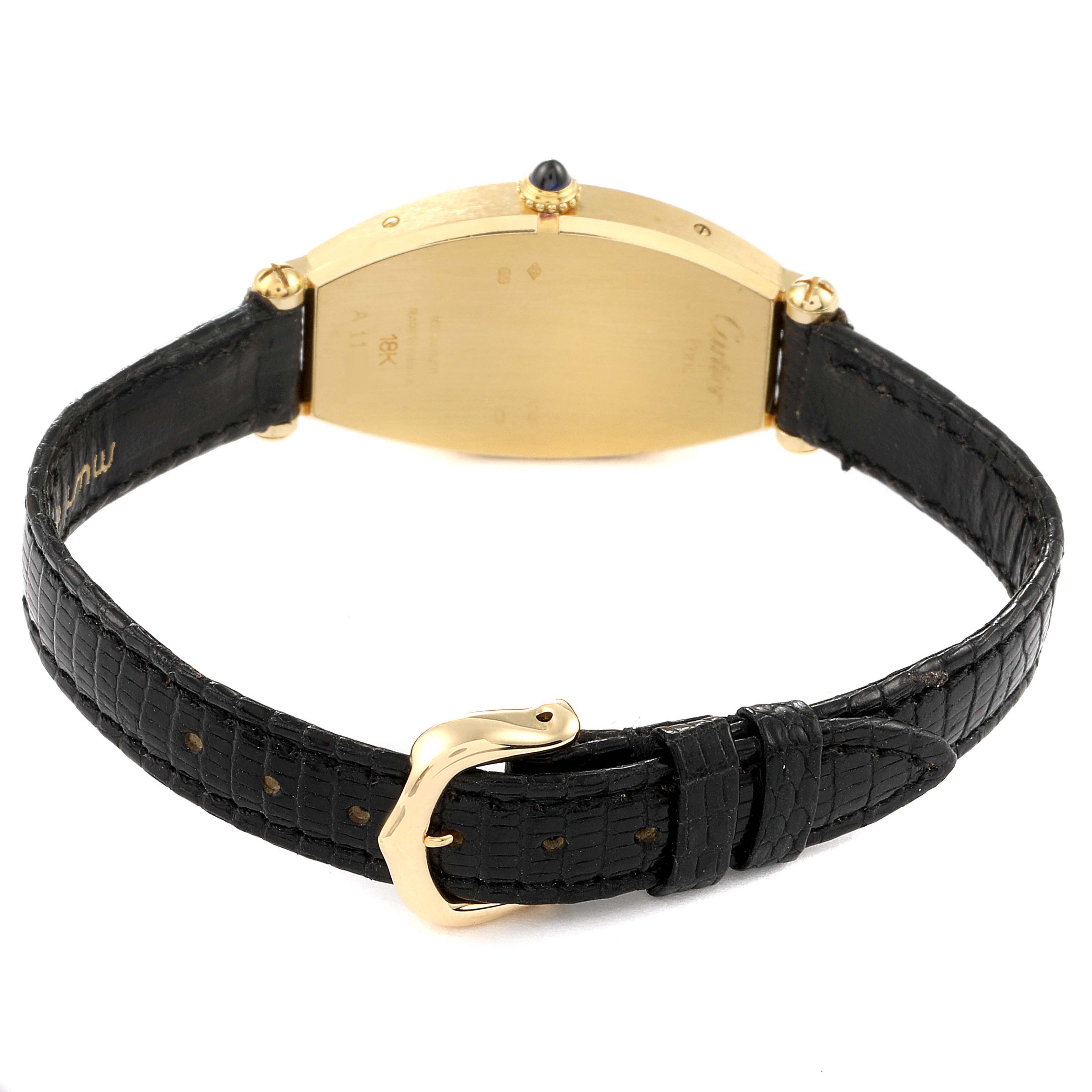 The image shows the back view of the gold case and black leather strap of a Cartier Tortue Women's Yellow Gold Silver Dial Women's Yellow Gold Silver Dial watch.