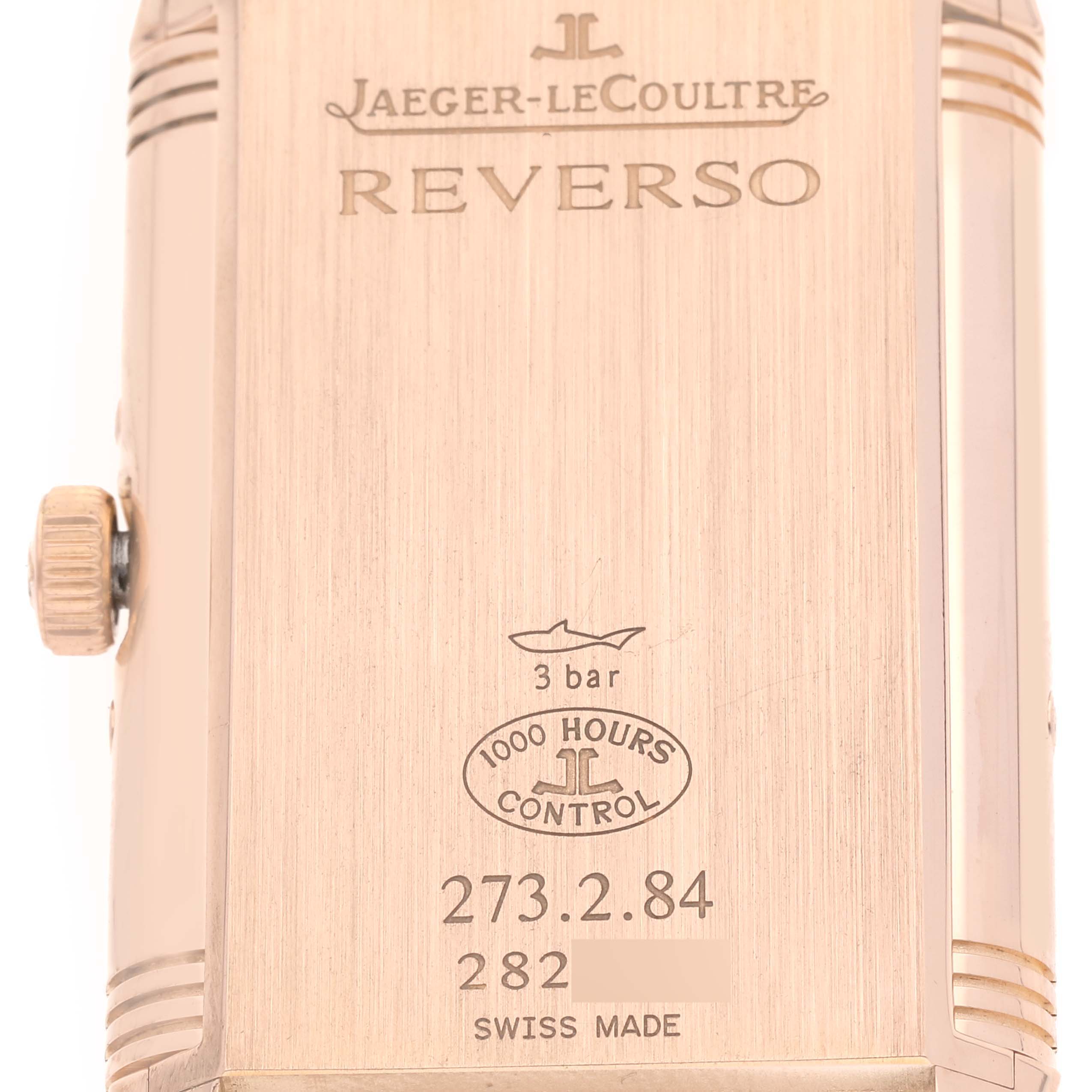 The image shows the back case of a Jaeger-LeCoultre Reverso watch, featuring the brand's logo, model details, and water resistance information.